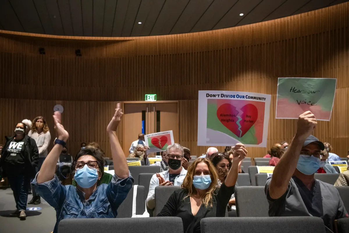 Commissioners seated around a long table during a California Citizens Redistricting Commission meeting in Sacramento, with staff laptops and microphones visible, news photography style
