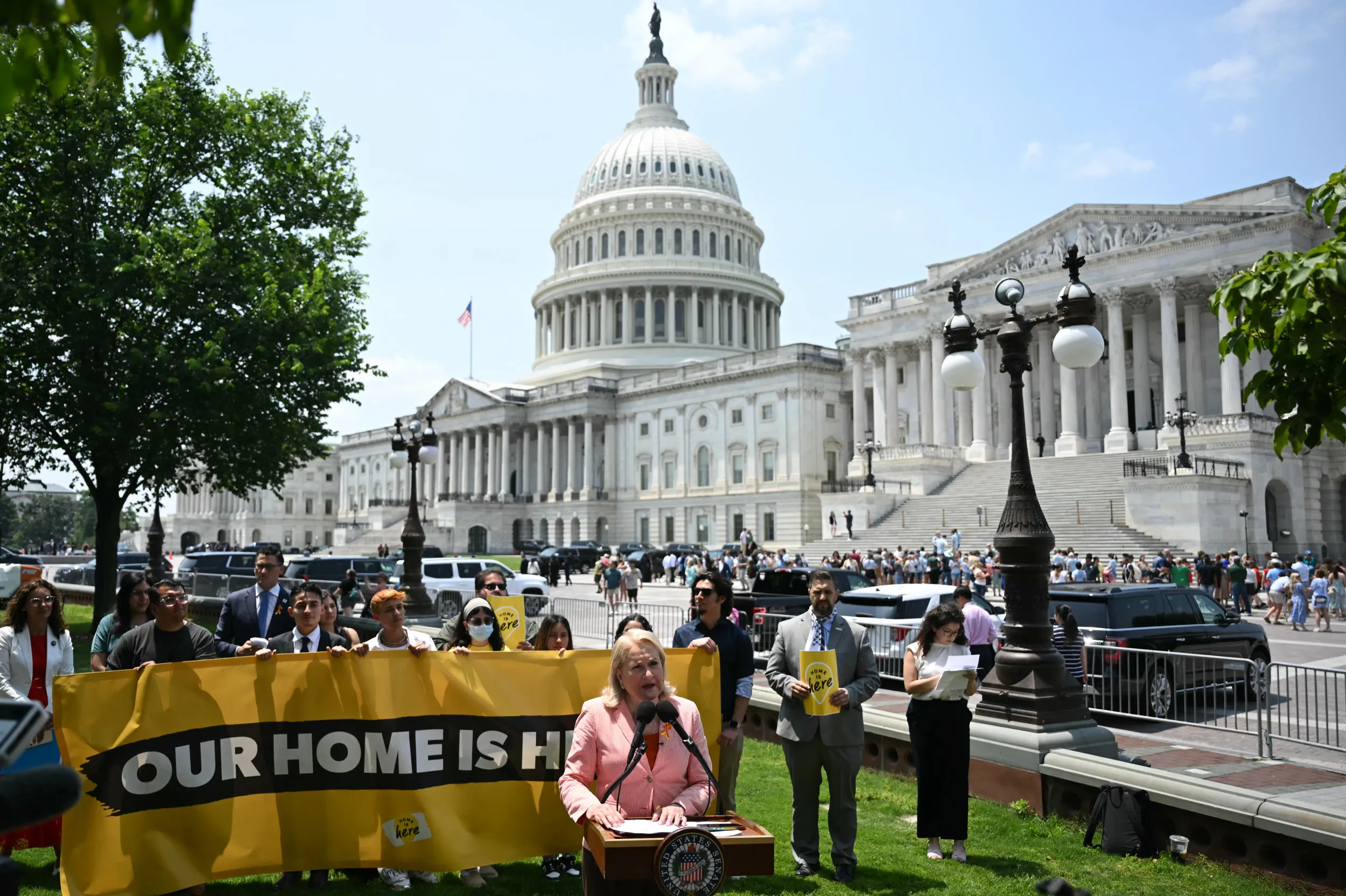 Customs and Border Protection officers standing near a passenger gate area at El Paso International Airport during a busy travel period, news photo style