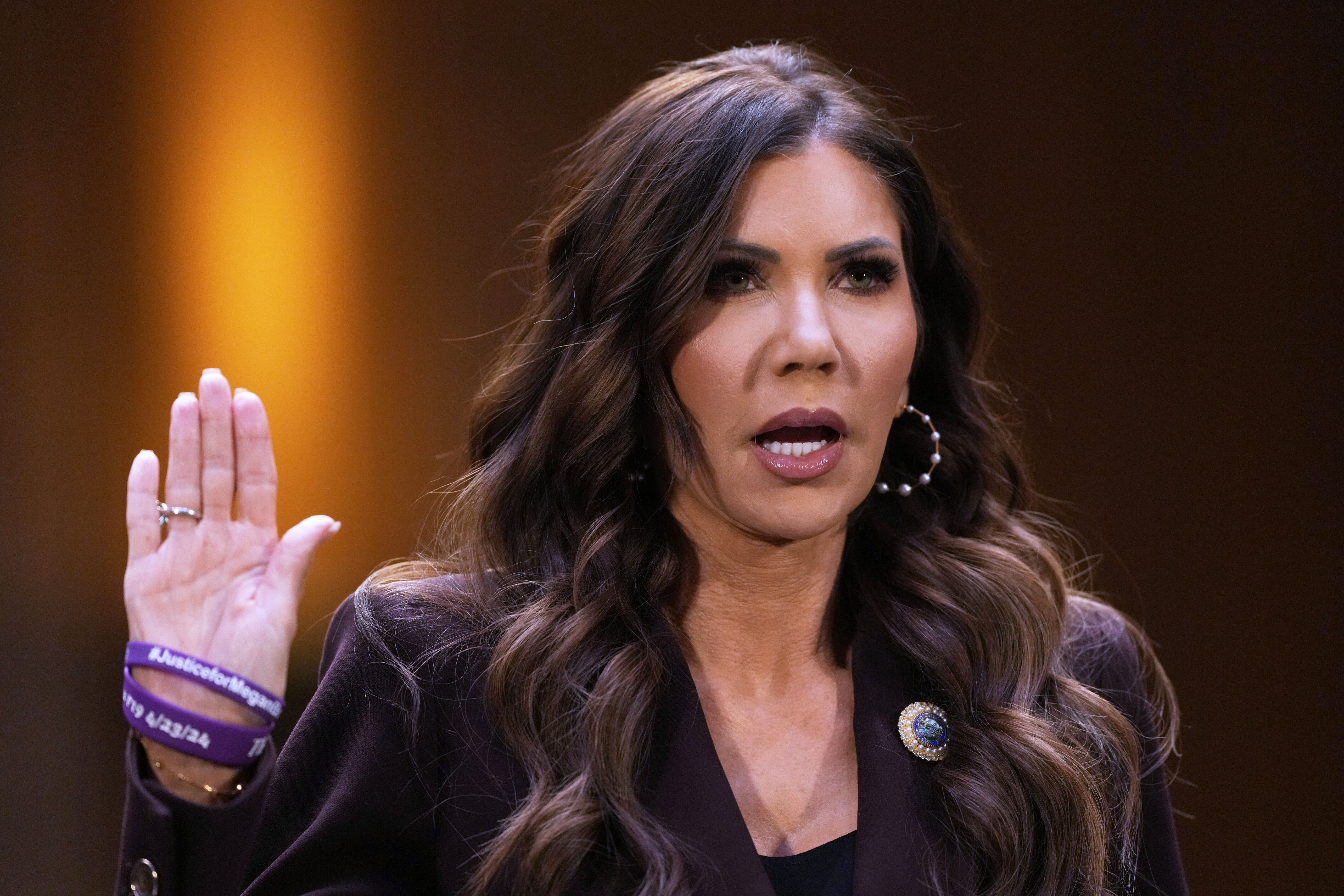 DHS Secretary Kristi Noem seated at a witness table in a Senate hearing room, facing lawmakers, news photography style