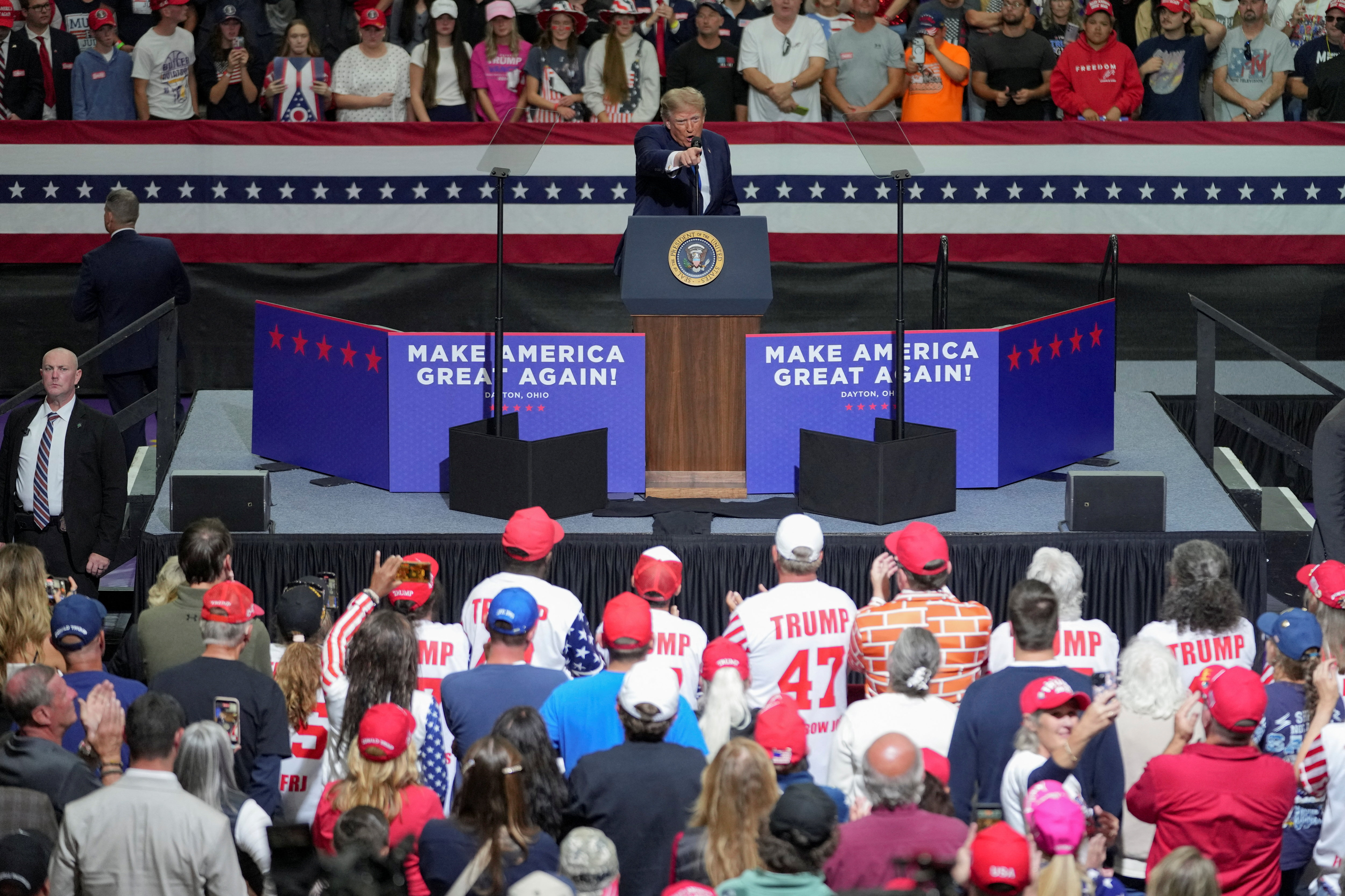 Donald Trump speaking at a campaign rally in Ohio, standing at a podium in front of a crowd