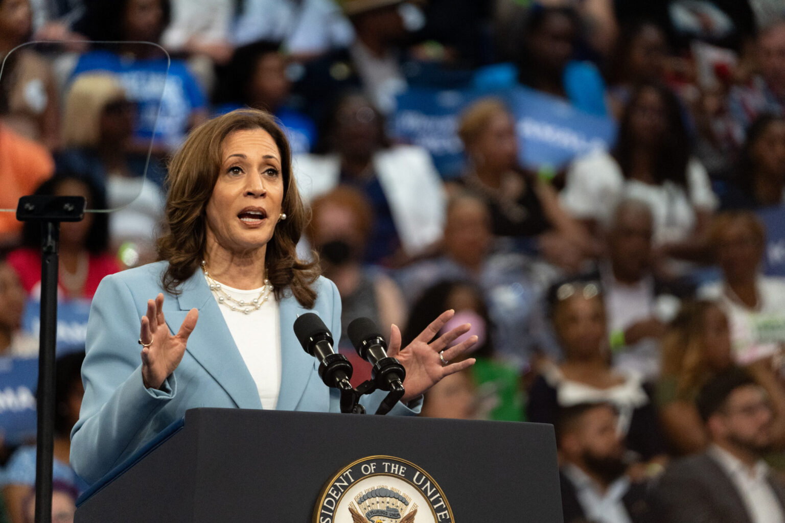 Elaine Luria speaking at a public campaign event in Virginia, standing at a podium in front of supporters