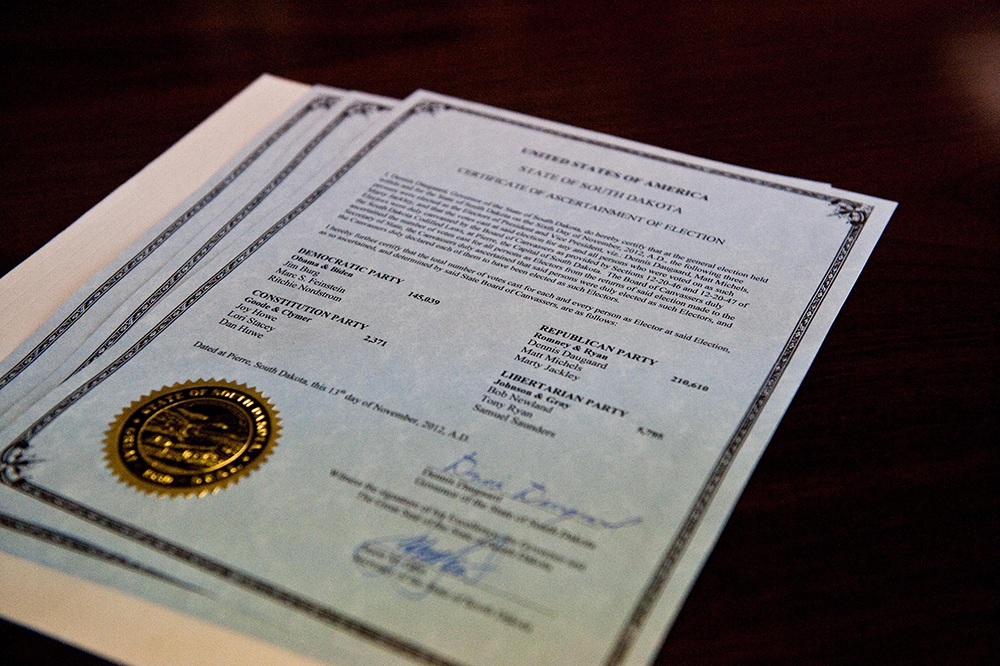 Electoral vote certificates and related paperwork displayed in an official setting, illustrating how Electoral College votes are recorded and transmitted