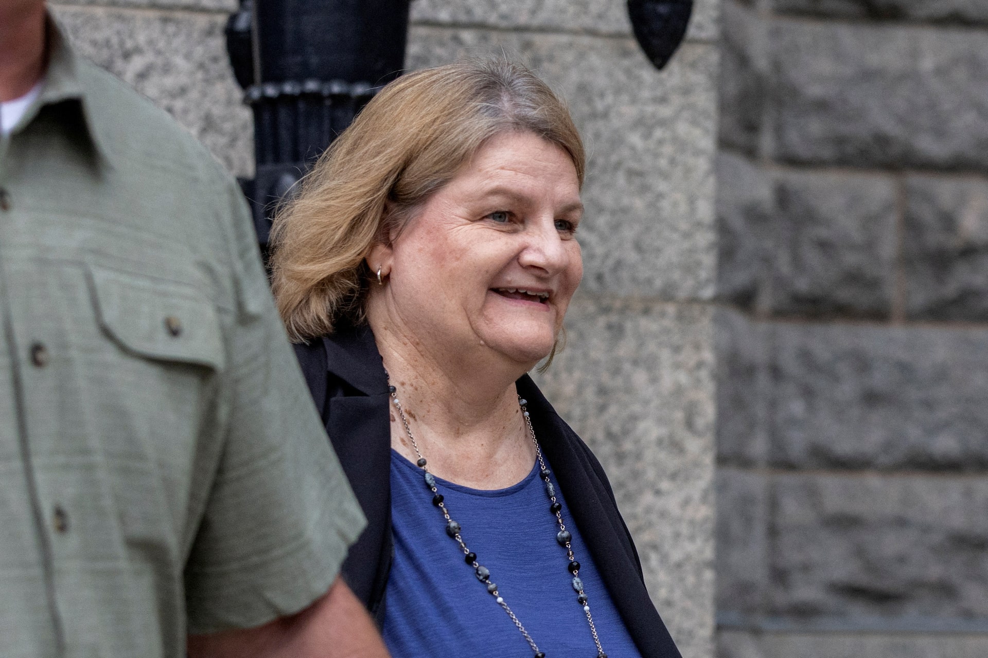 Former Milwaukee County Circuit Court judge Hannah Dugan outside a federal courthouse, standing near the entrance as attorneys and security move around the steps
