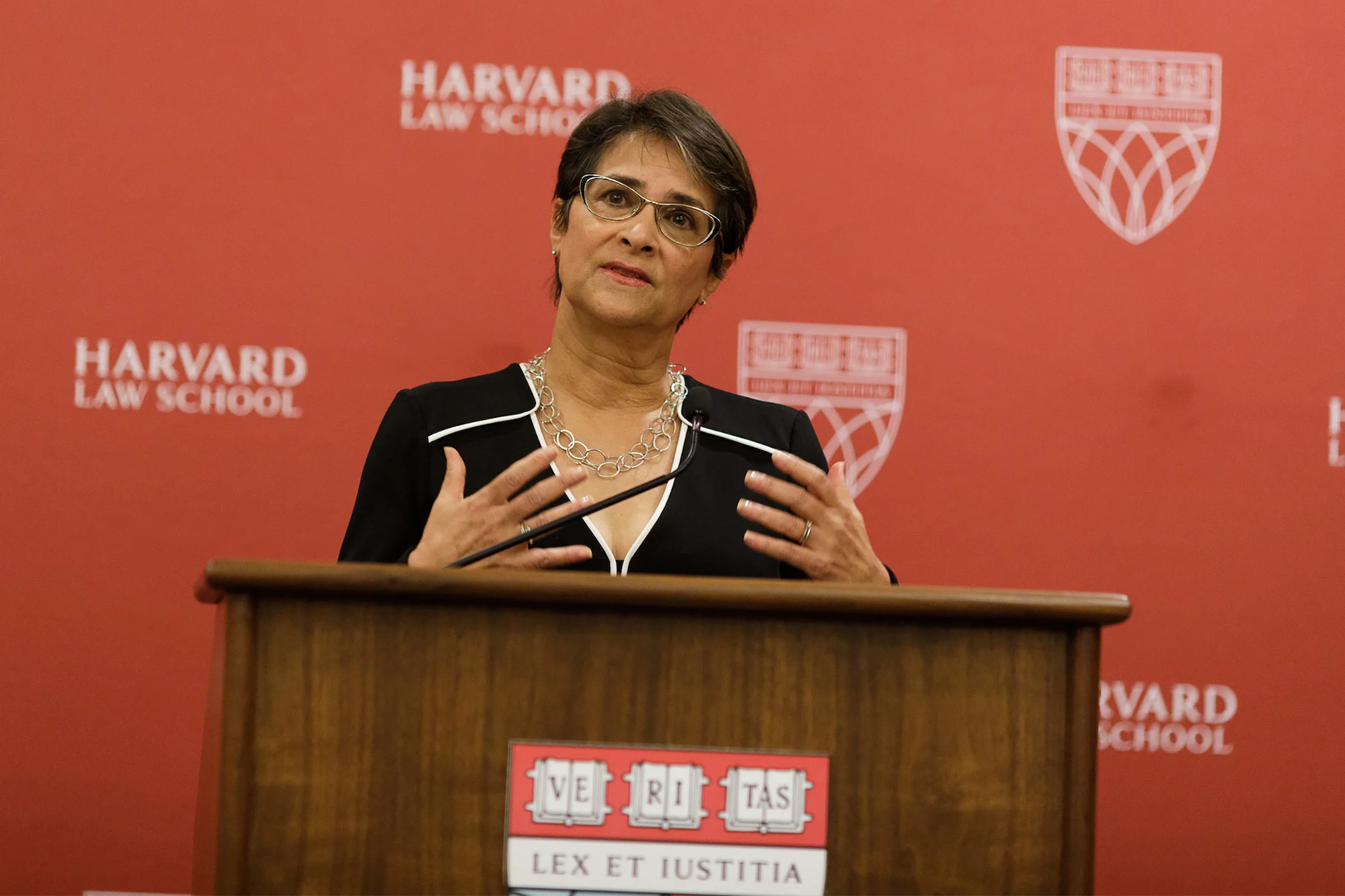 Historian Martha Jones speaking at a university lectern during a public lecture, candid event photography style