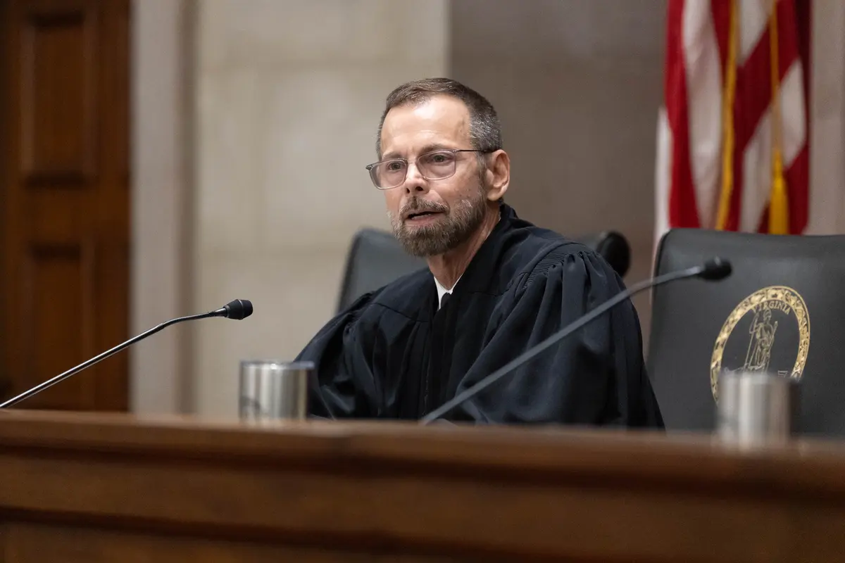 Justice D. Arthur Kelsey standing outdoors near the Virginia Supreme Court building in Richmond, news photography style