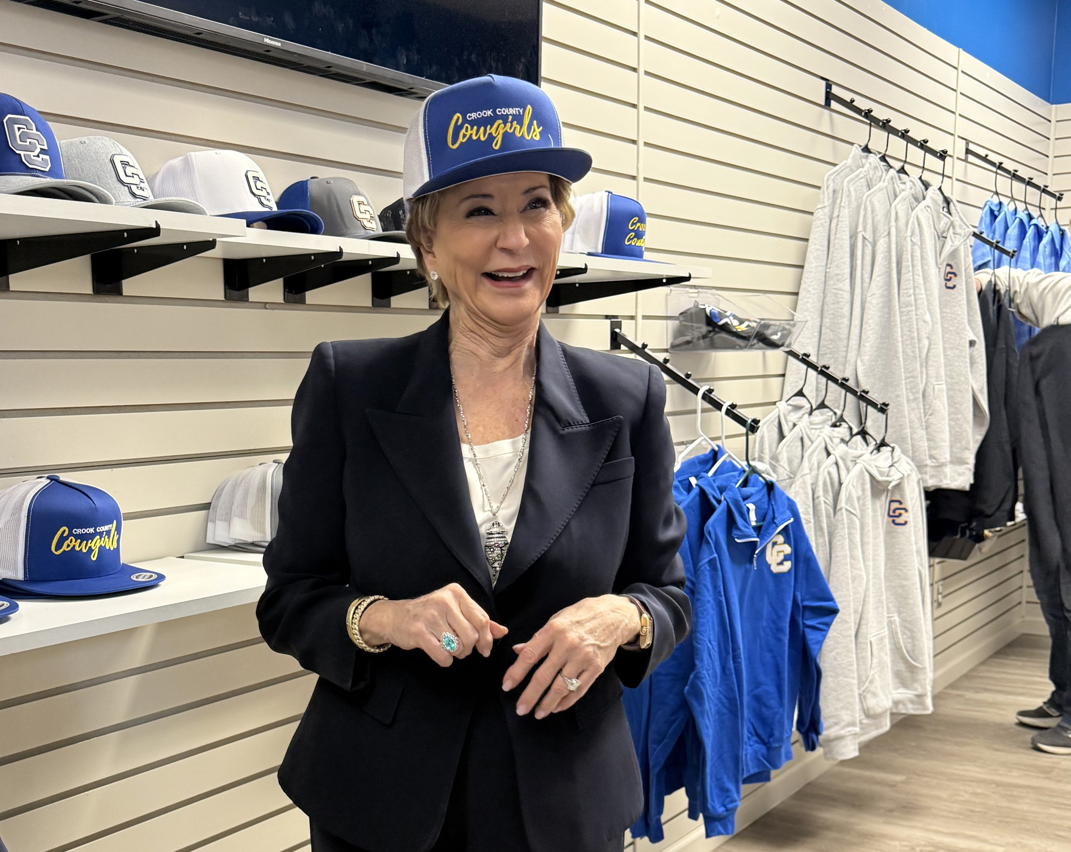 Linda McMahon walking through a government office hallway with Department of Education signage visible in the background, news photography style