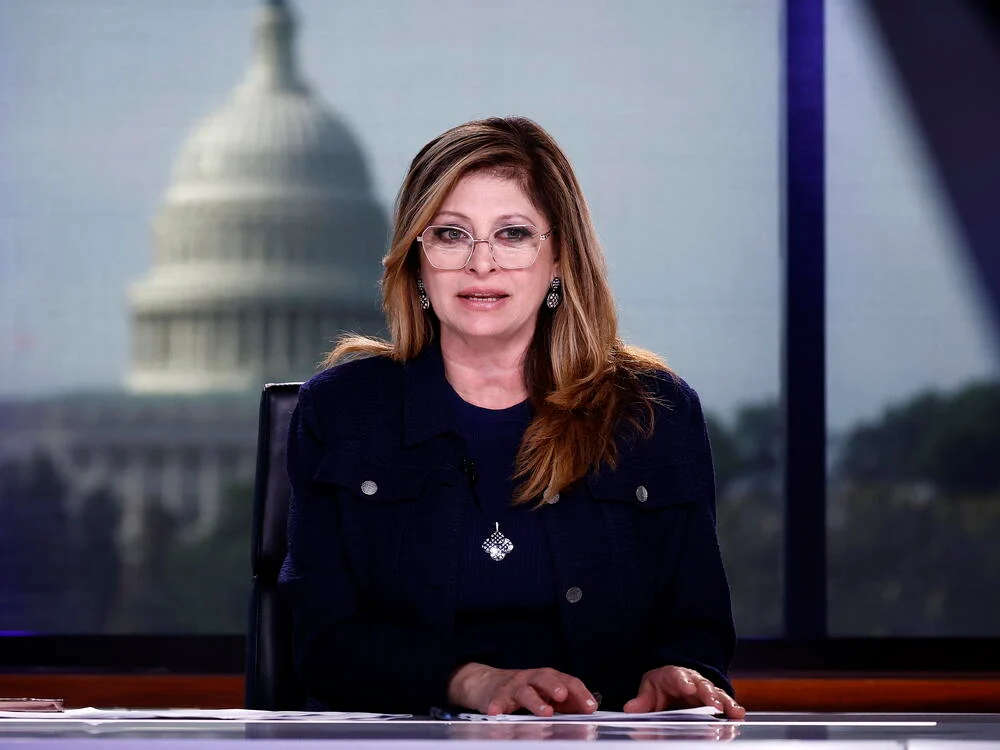 Maria Bartiromo at a public event, photographed in a typical news setting with a neutral background