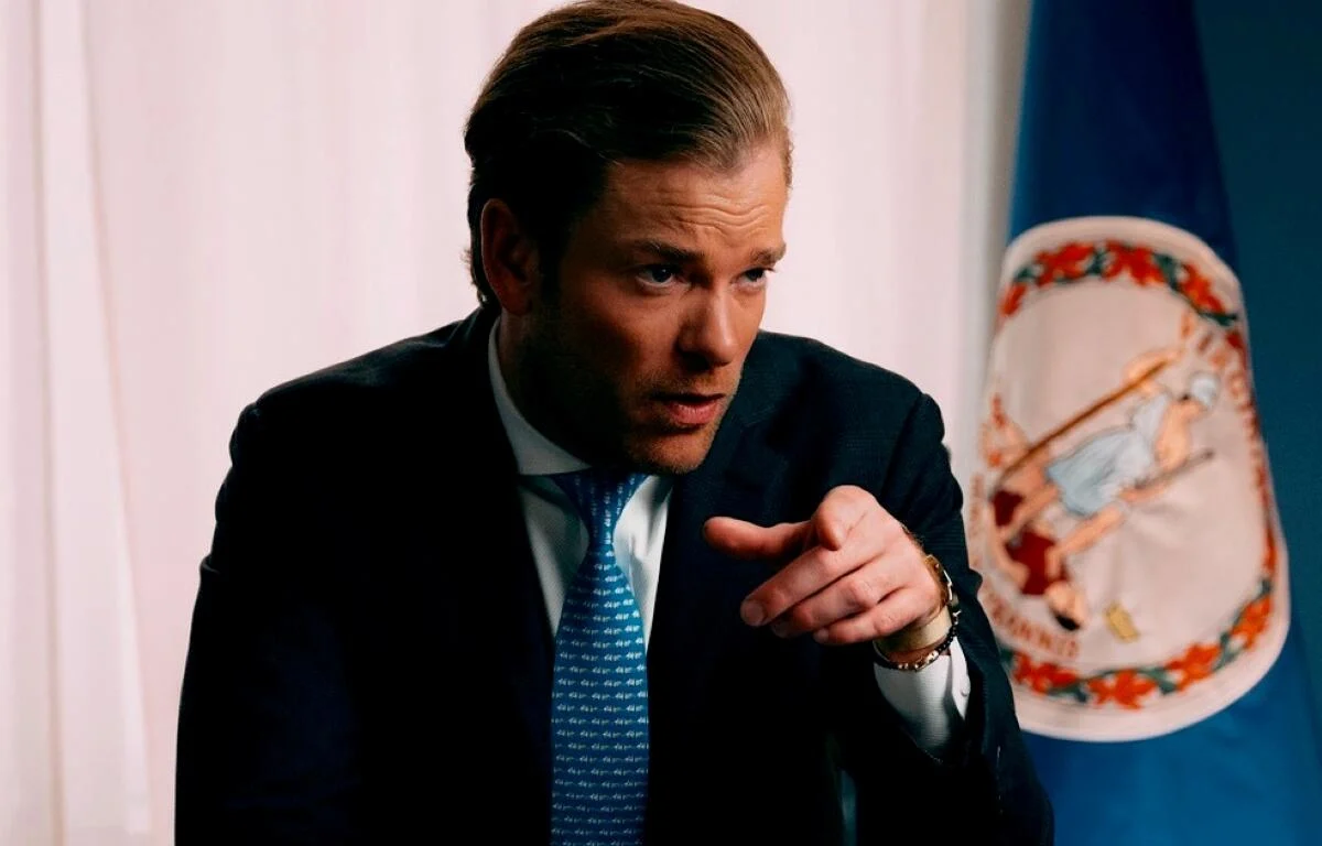 Mark Moran, a Virginia Senate candidate, standing outdoors at a campaign stop in Virginia speaking with attendees, news photography style