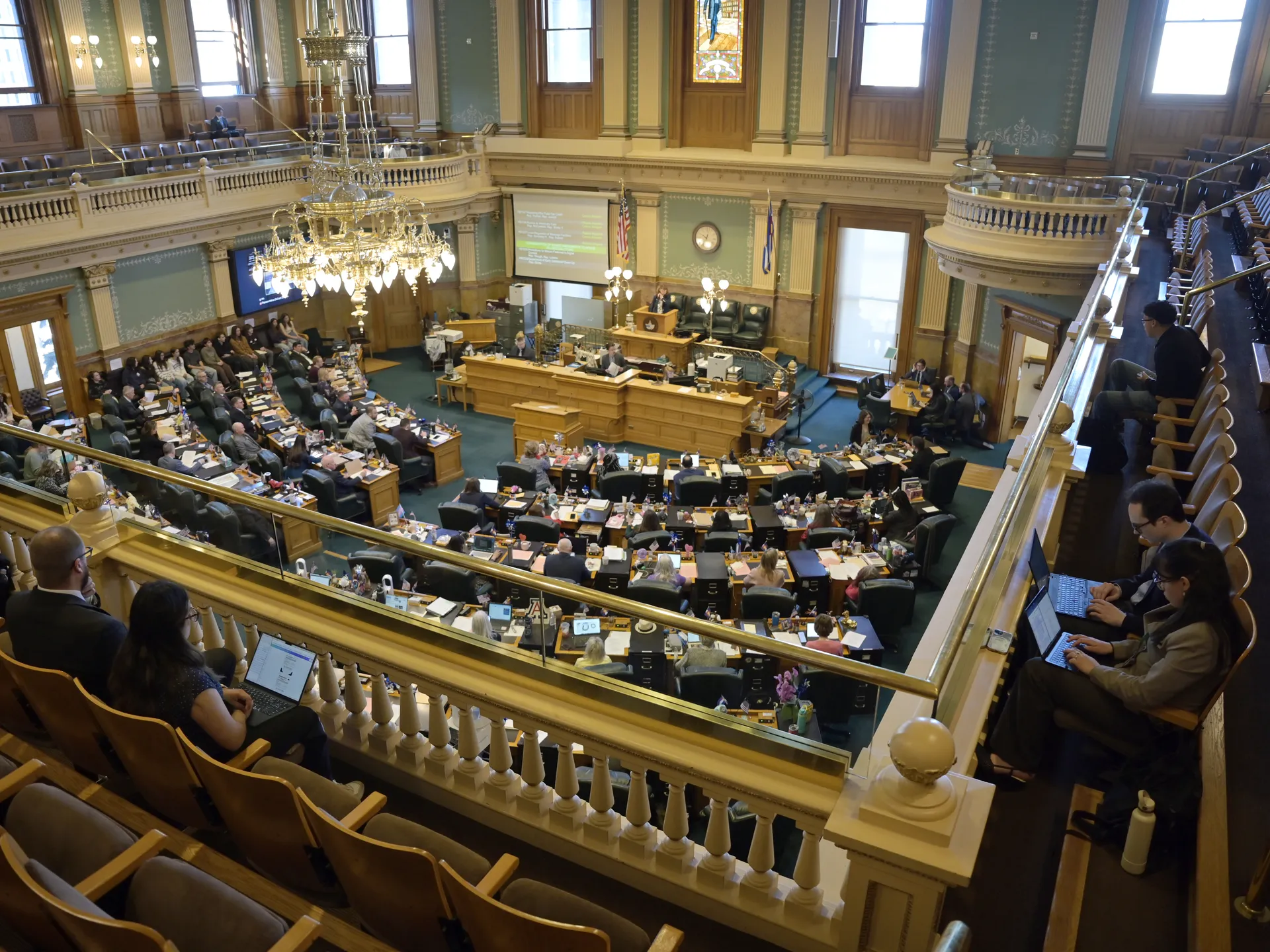 Members of the U.S. House of Representatives gathered in the House chamber during a legislative session, viewed from the gallery in a realistic news photo style