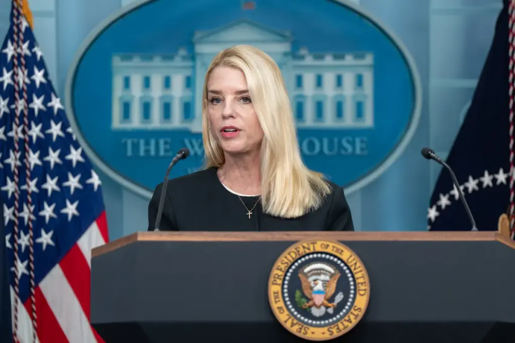 Pam Bondi speaking at a podium with Department of Justice signage in 2026, news photography style