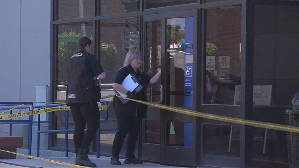 Police investigators standing outside a bank in Midlothian, Virginia, during an active investigation, with patrol cars in the background, news photography style