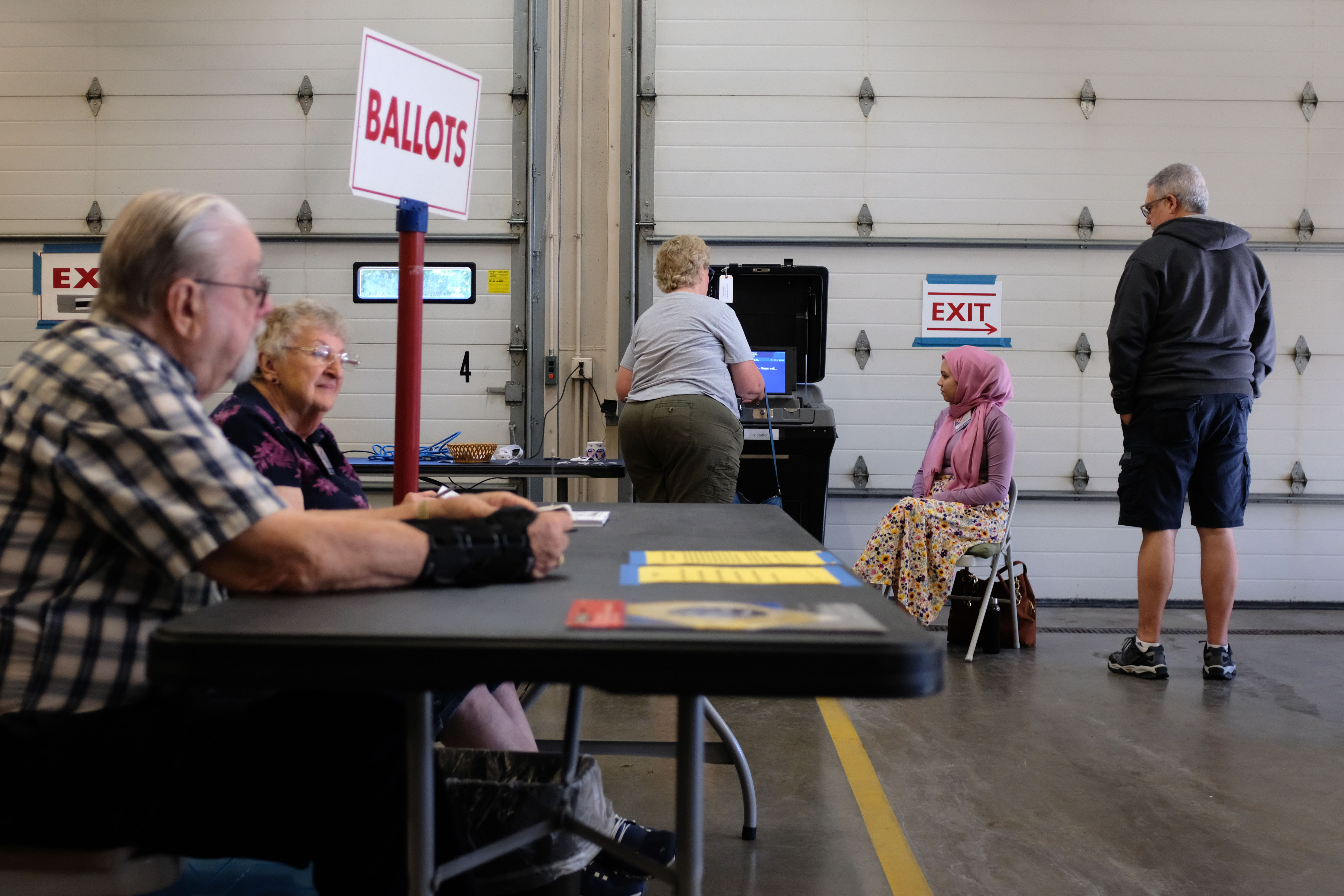 Poll workers checking in voters at a primary election polling place in Milwaukee, Wisconsin, candid news photography