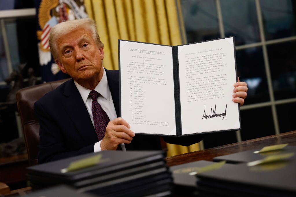 President Donald Trump at a desk during an executive order signing event