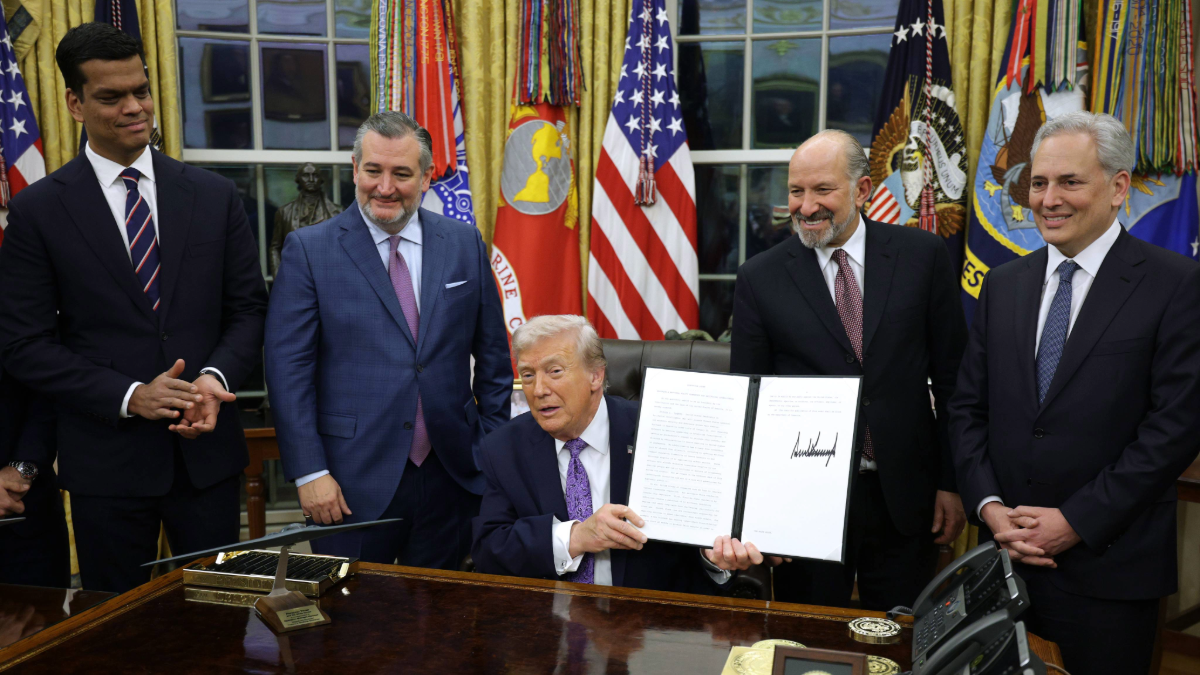 President Donald Trump at an event associated with an executive order, with the order document visible