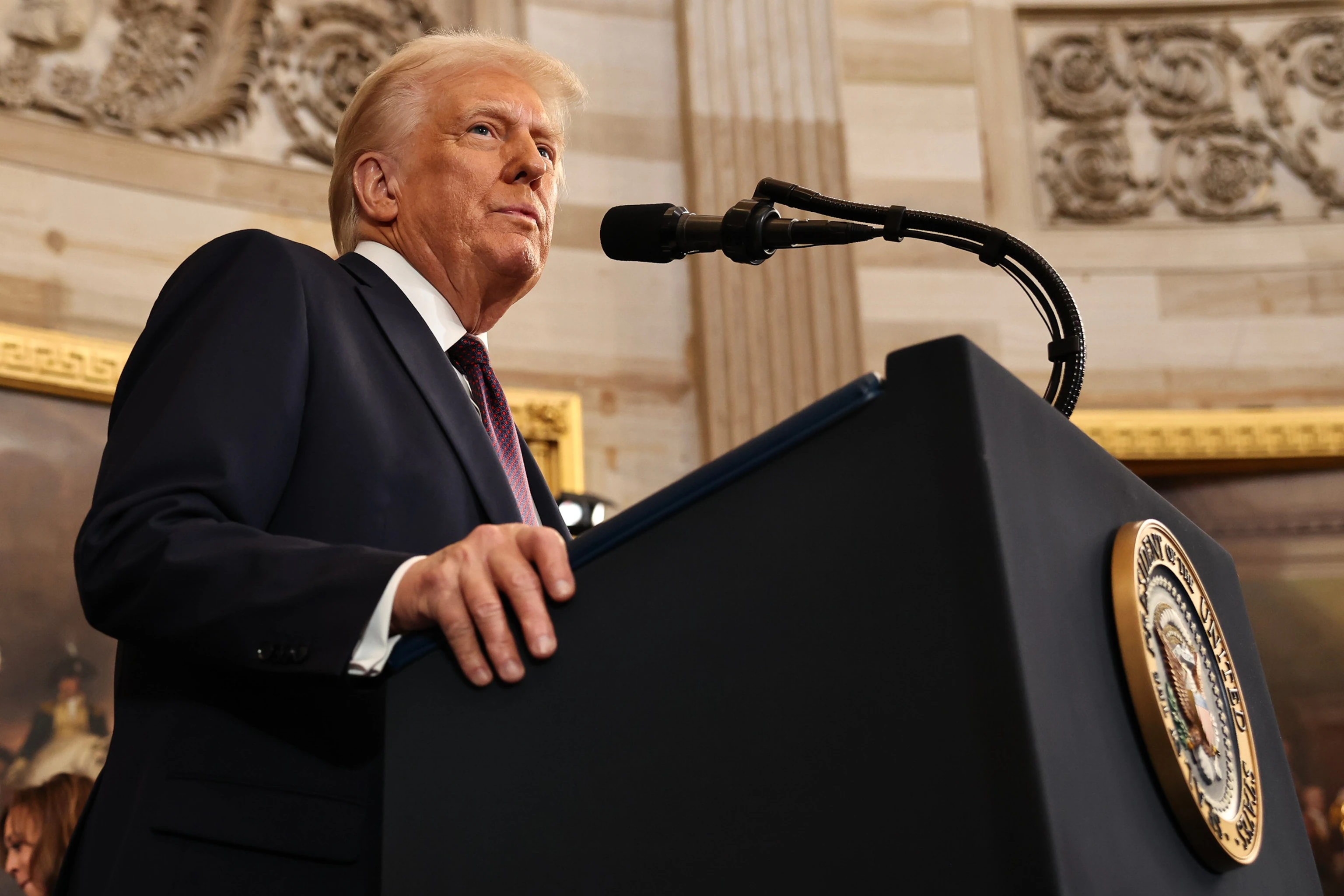 President Donald Trump speaking at a lectern during a public address in August 2026, with American flags in the background