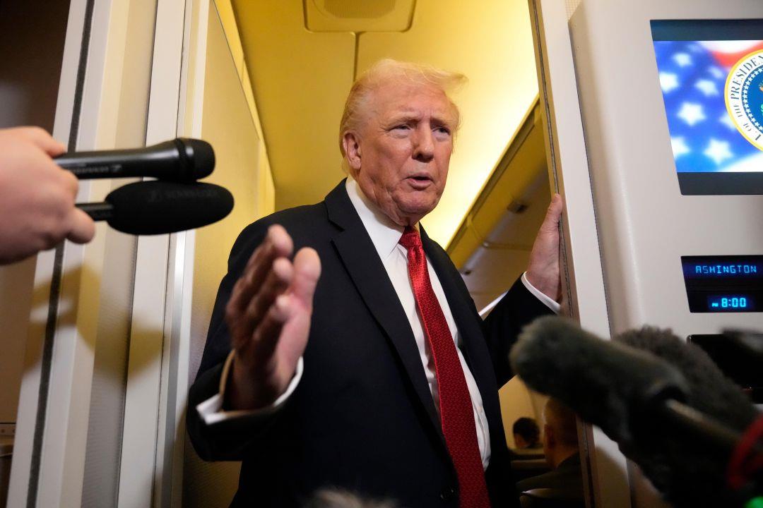President Donald Trump speaking to reporters aboard Air Force One