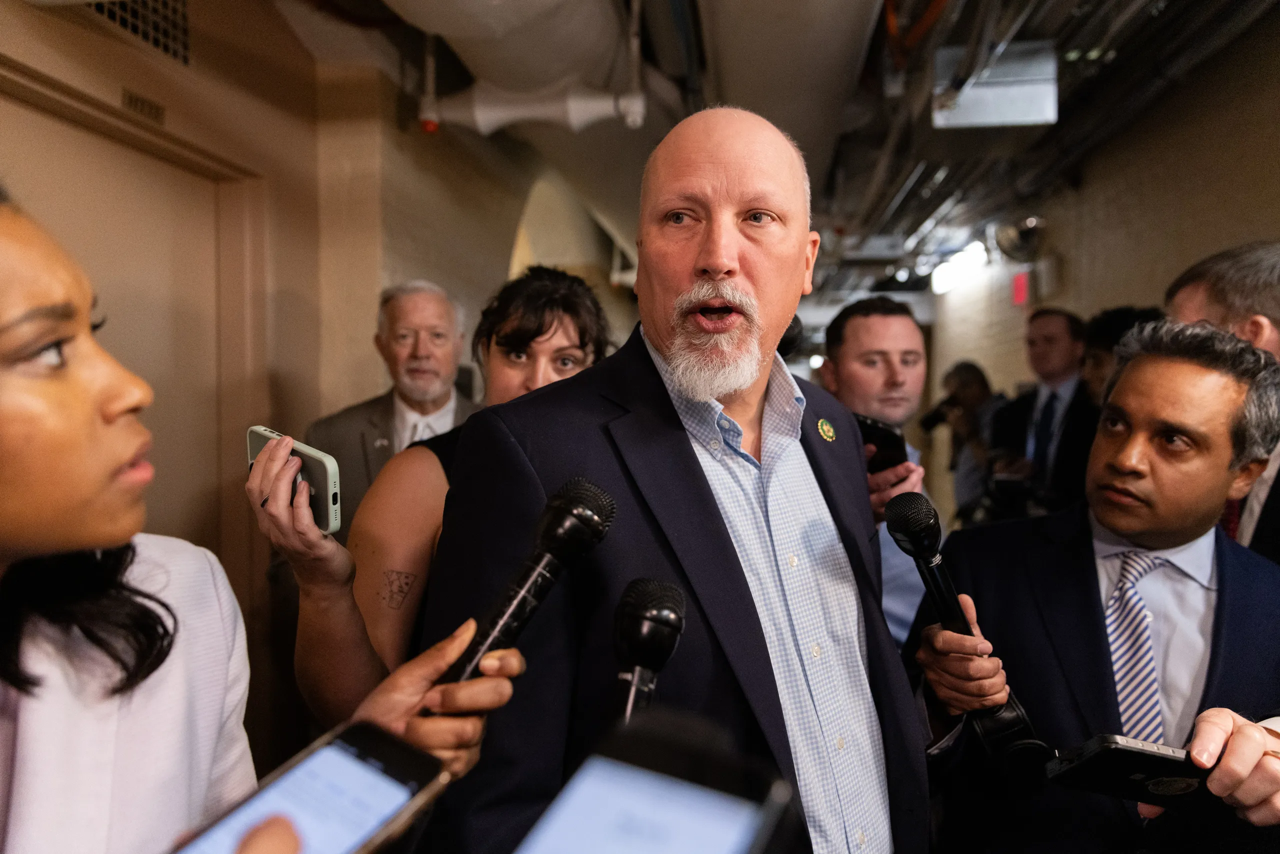 Rep. Chip Roy speaking to reporters in a hallway of the U.S. Capitol, news photography style