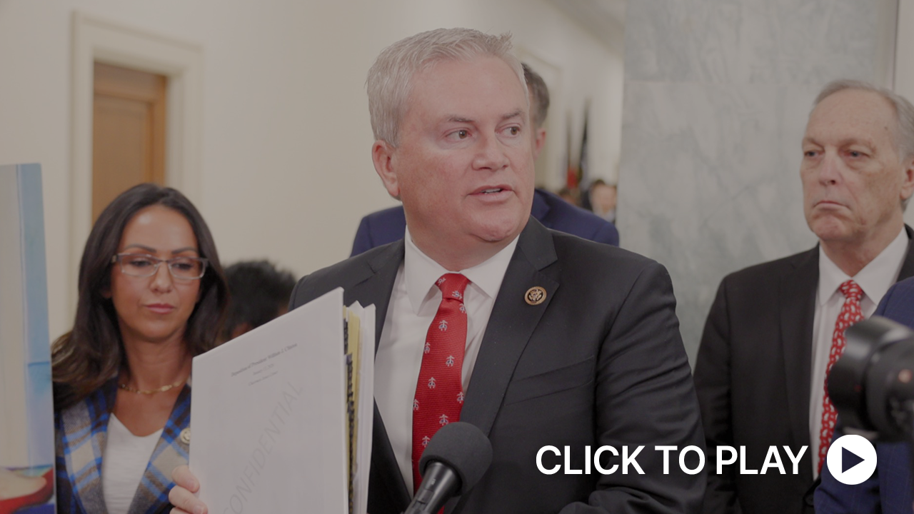 Representative James Comer seated at the dais during a House Oversight Committee hearing, looking down at documents with a microphone in front of him, news photography style