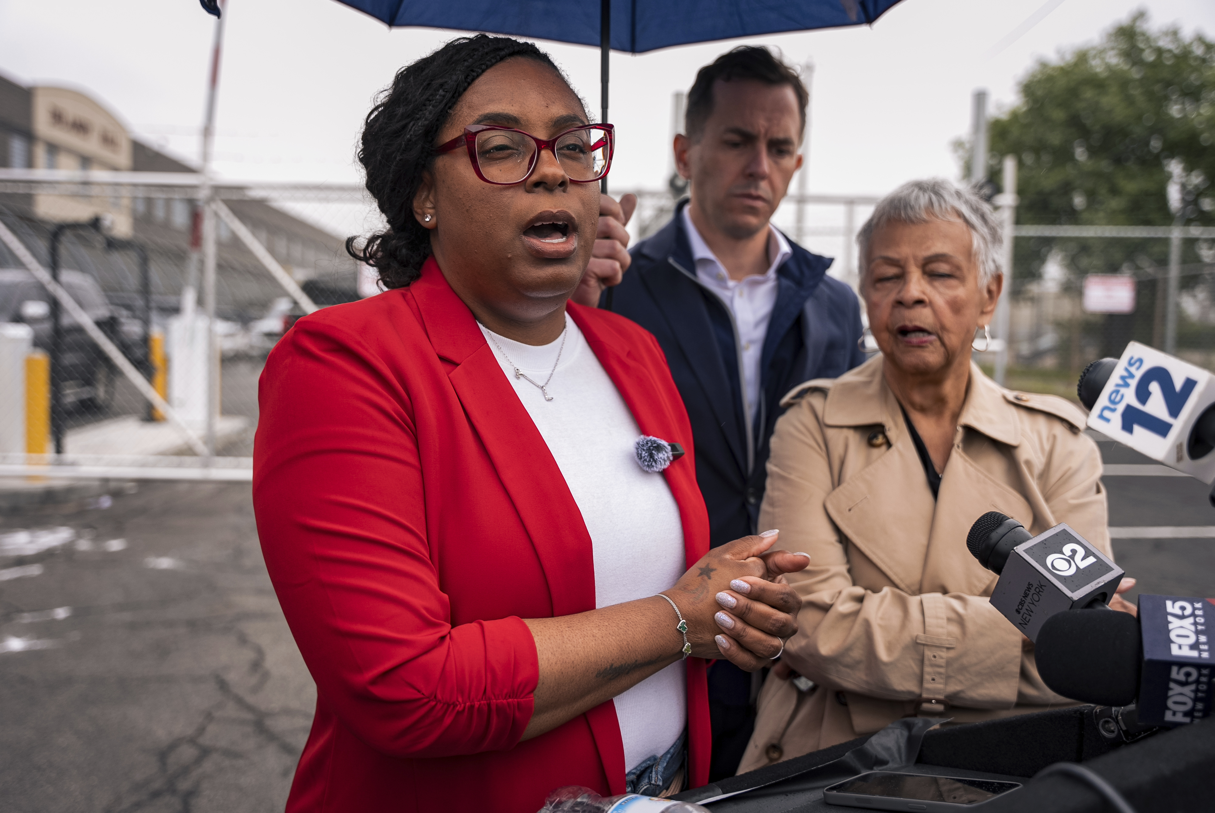 Representative LaMonica McIver speaking at a podium during a public appearance, with microphones visible