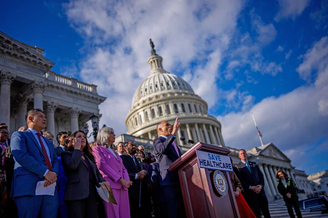 Representatives clustered on the House floor during a recorded vote in Washington, DC, with members talking and moving between rows, news photography style
