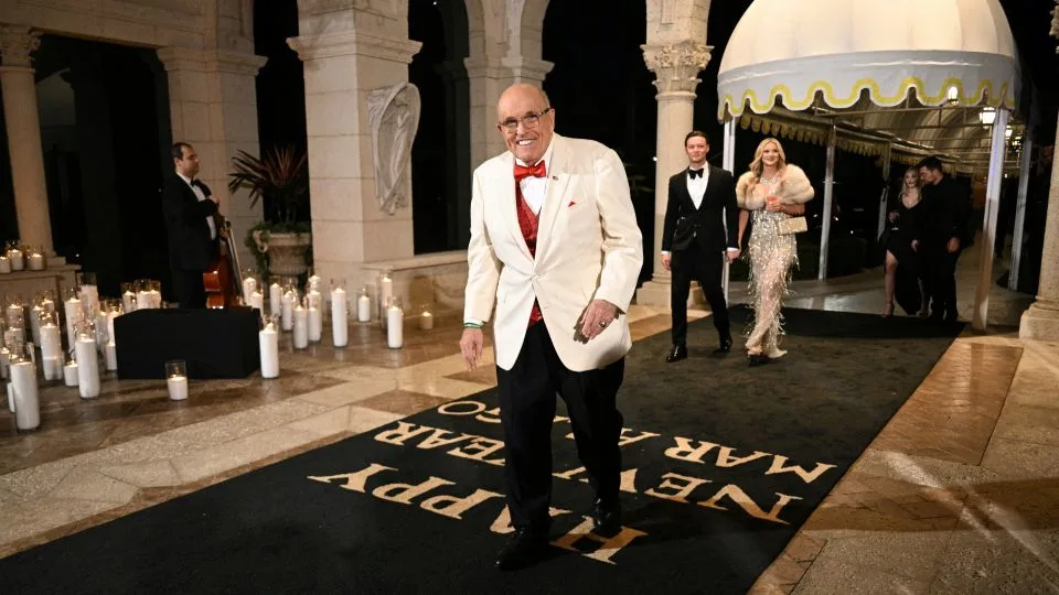 Rudy Giuliani arriving outdoors at night for a New Year's Eve celebration at Mar-a-Lago in Palm Beach, Florida, news photography style