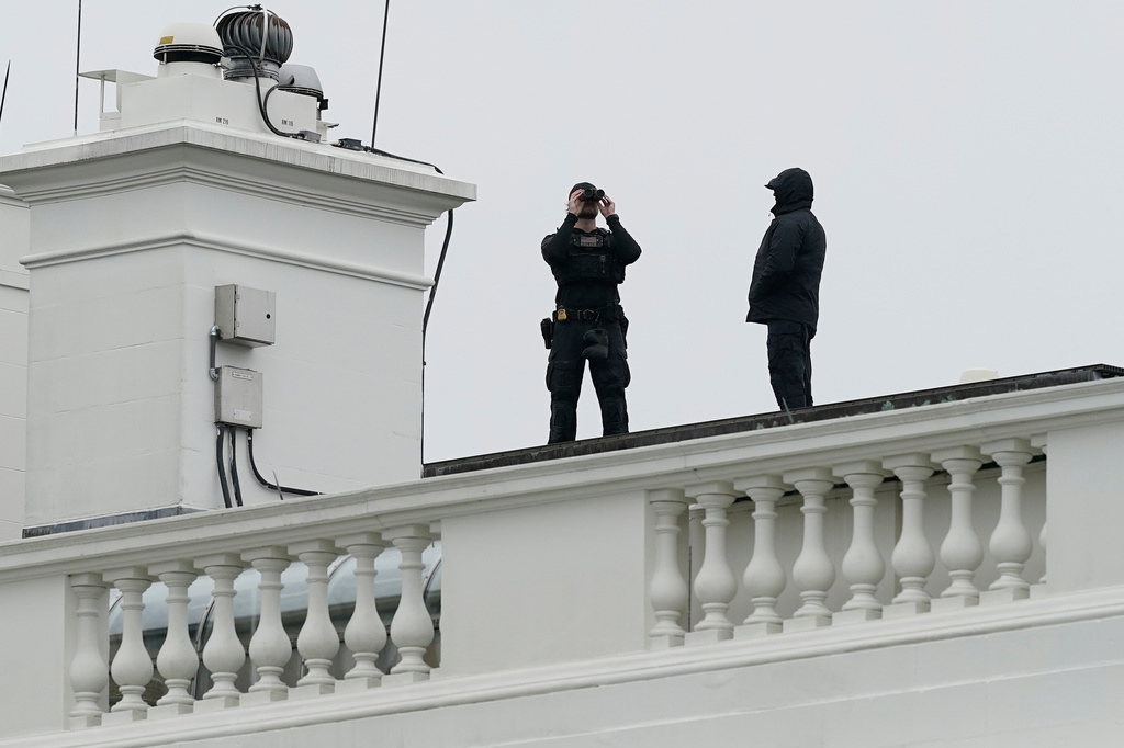 Secret Service agents positioned on the White House roof after a shooting incident near the perimeter, Washington, DC, in a realistic news photo