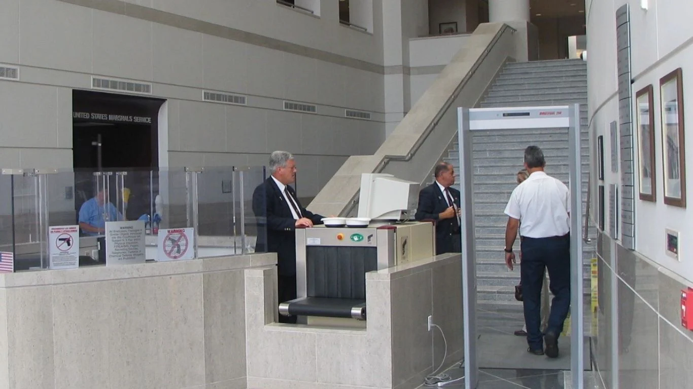Security screening area inside a federal courthouse with metal detectors and security personnel