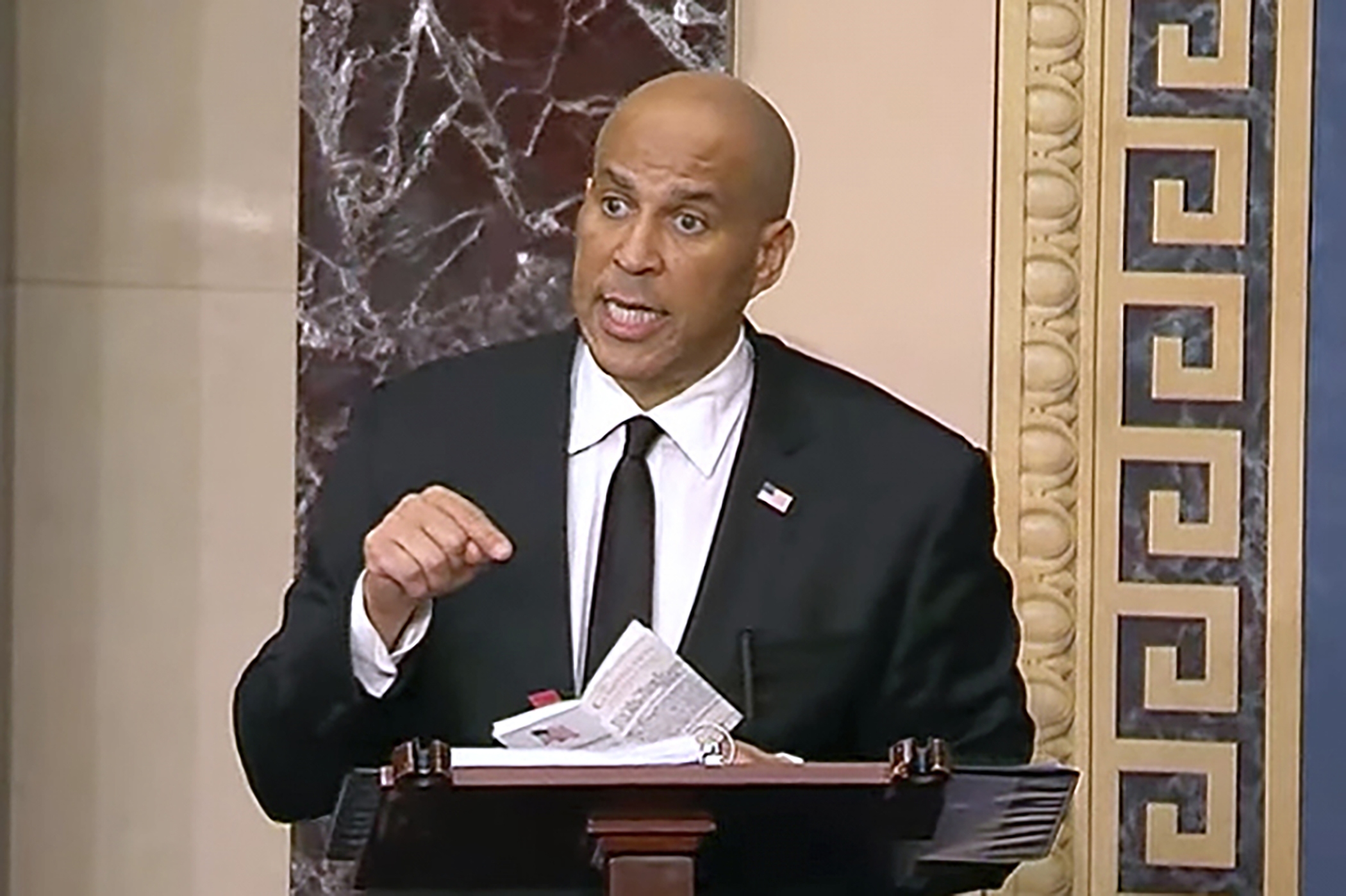 Sen. Cory Booker speaking to reporters in a U.S. Capitol hallway, news photography style