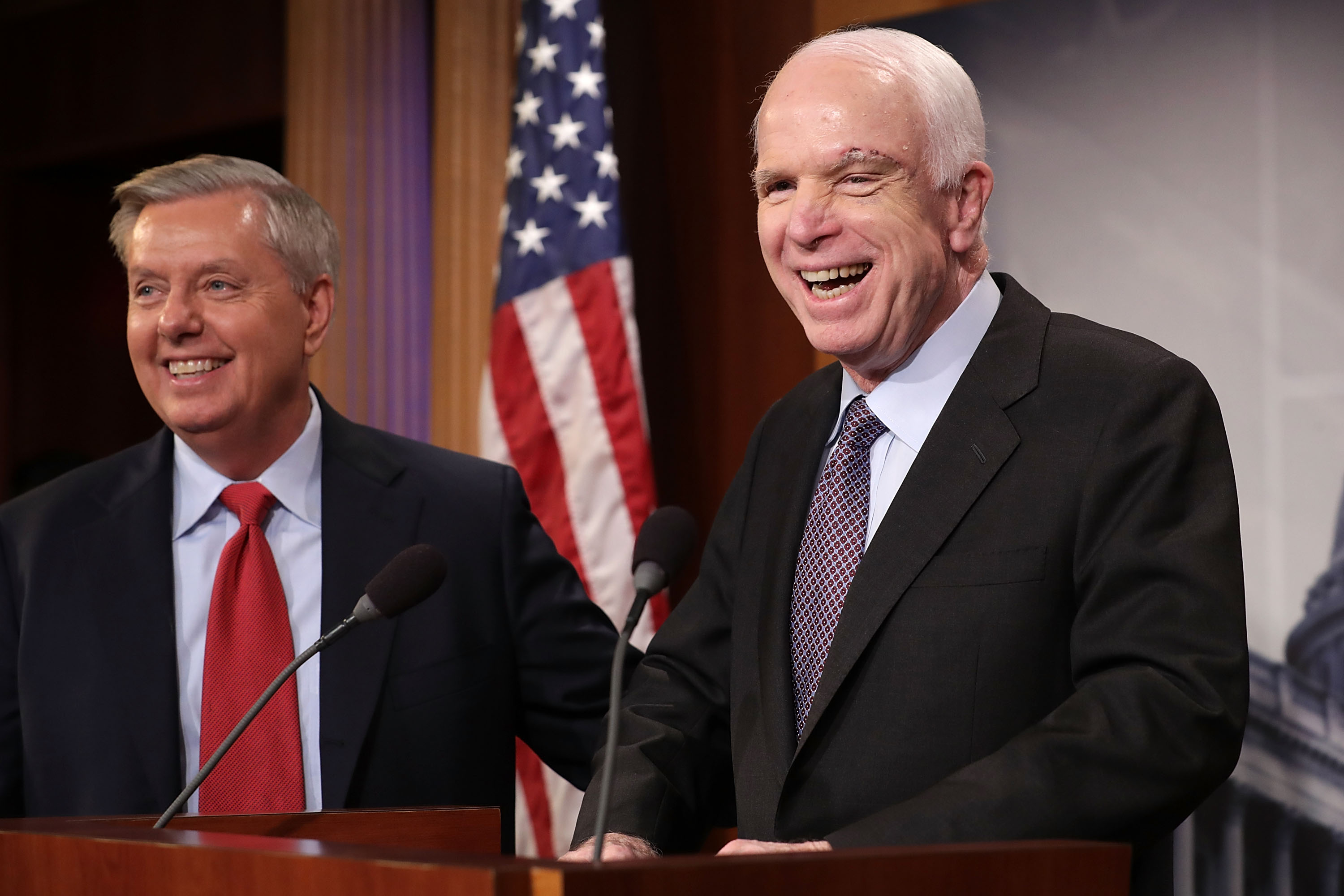Senators Lindsey Graham and John McCain during a public visit in Ukraine in late 2016, standing with officials in a formal setting.