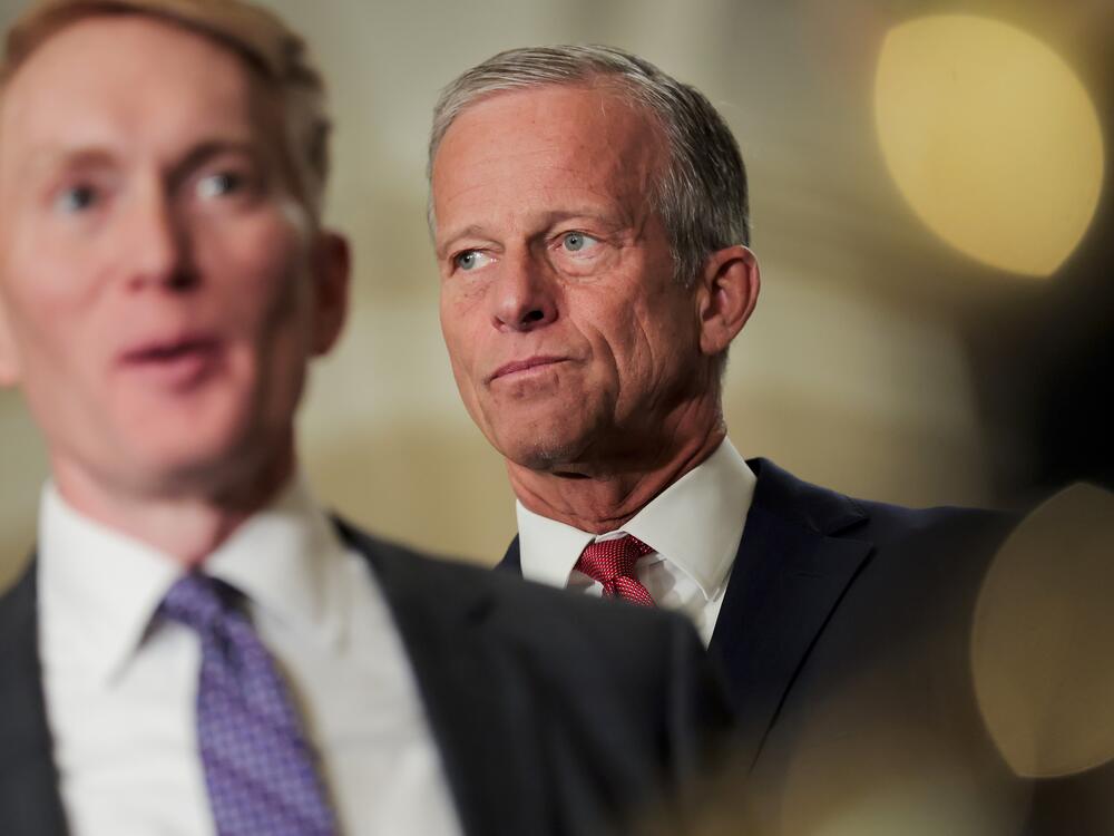 Senators on the U.S. Senate floor during a late-night debate with staffers seated nearby, news photography style