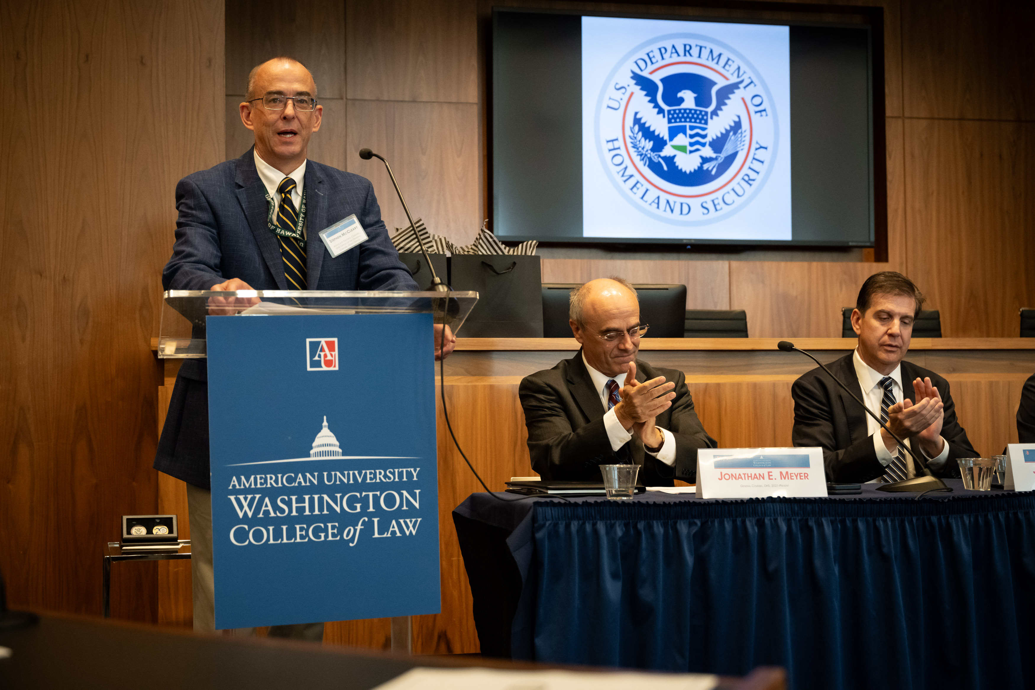 The Department of Homeland Security seal displayed on a wall or podium at an official DHS event