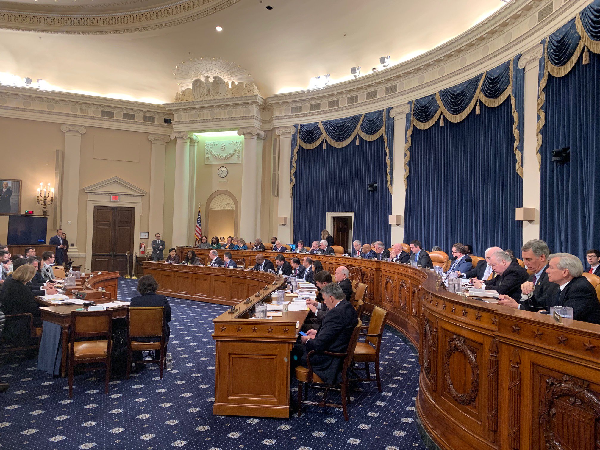 The House Ways and Means Committee hearing room, with the committee dais and witness table visible.