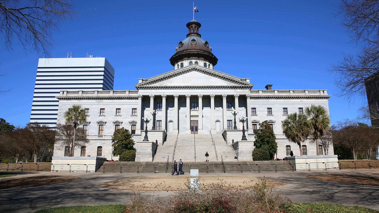 The South Carolina State Capitol building in Columbia seen through trees on a clear day, news photography style