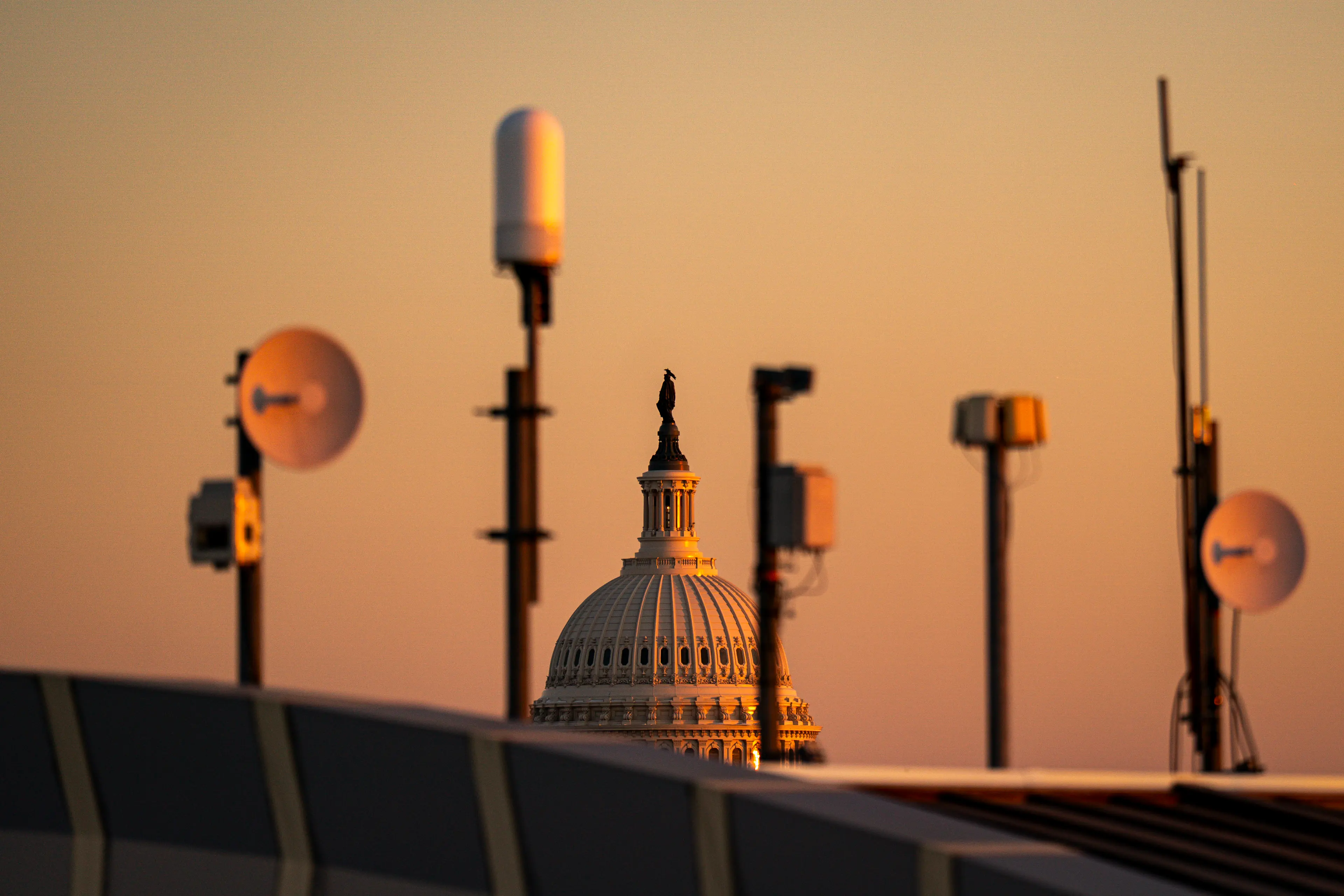 The United States Capitol in Washington, D.C., photographed in daylight with people walking on the grounds, news photography style