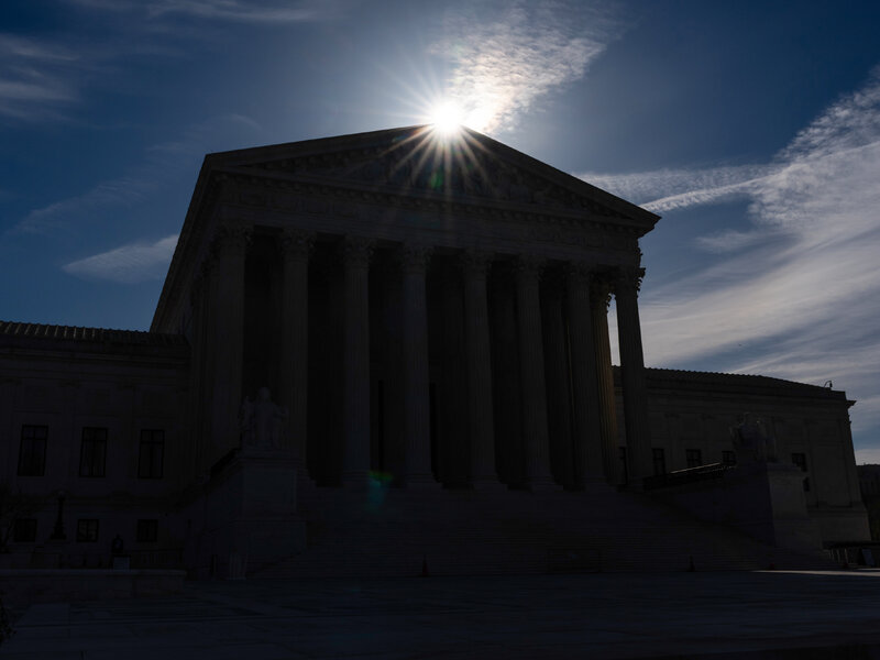 The United States Supreme Court building at dusk with the front steps and columns visible, news photography style