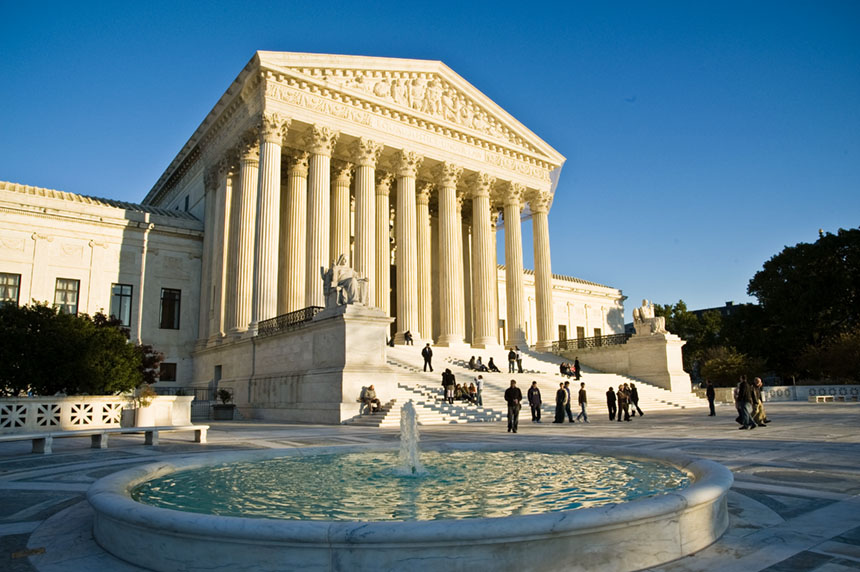 The United States Supreme Court building in Washington, D.C., with people walking on the plaza, news photography style
