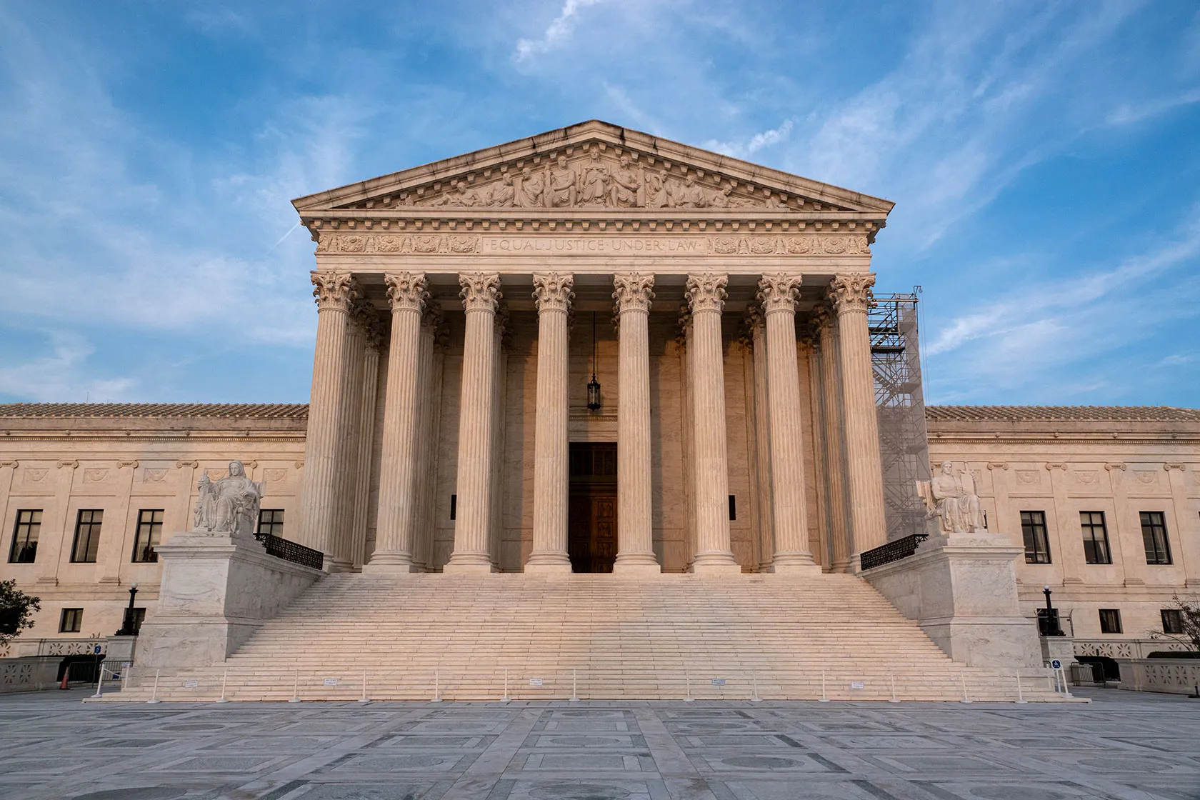 The United States Supreme Court building in Washington, D.C. on a clear day, photographed from street level with the front steps and columns visible, news photography style