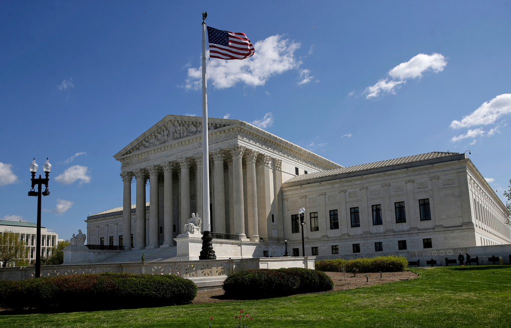 The United States Supreme Court building on a clear spring day, photographed from street level with the front steps and columns in view, news photography style