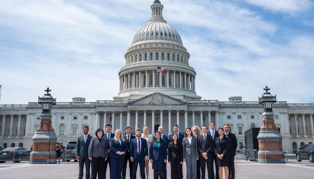 The east front of the United States Capitol in Washington, D.C., photographed on an overcast day with pedestrians in the foreground, news photography style