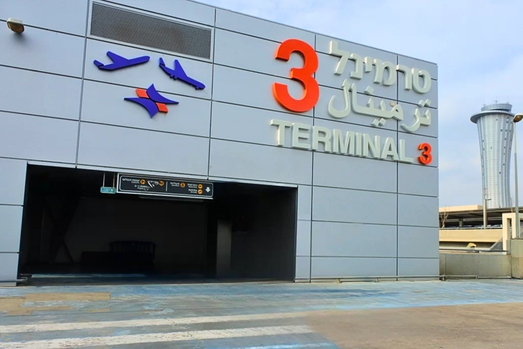 The exterior of Ben-Gurion Airport Terminal 3 with roadway traffic and terminal signage visible