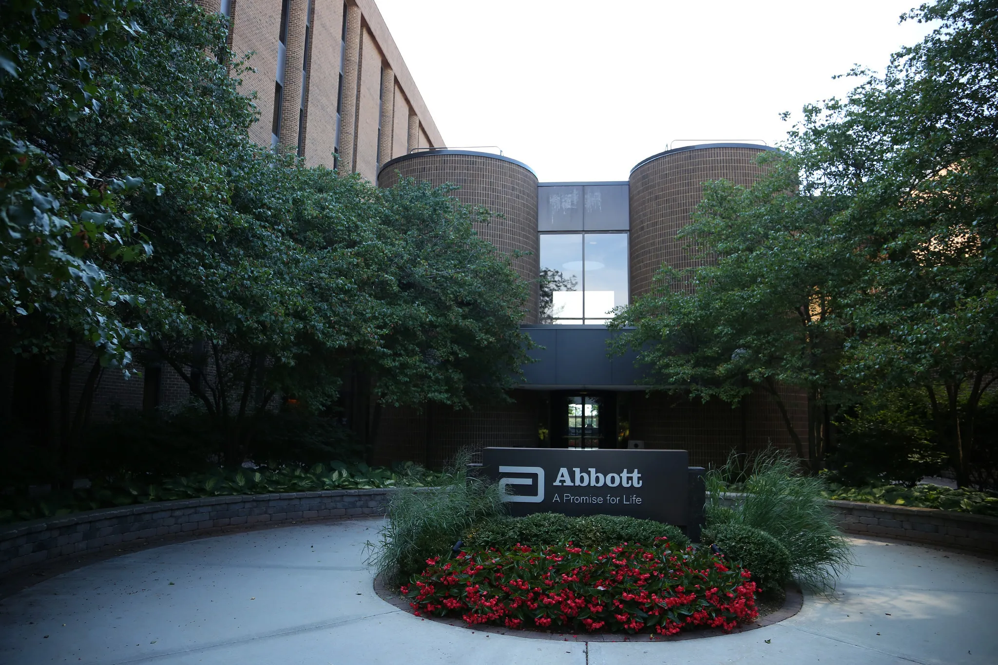 The exterior of an Abbott Laboratories facility in Illinois, showing the corporate campus entrance and company signage in a real-world photograph
