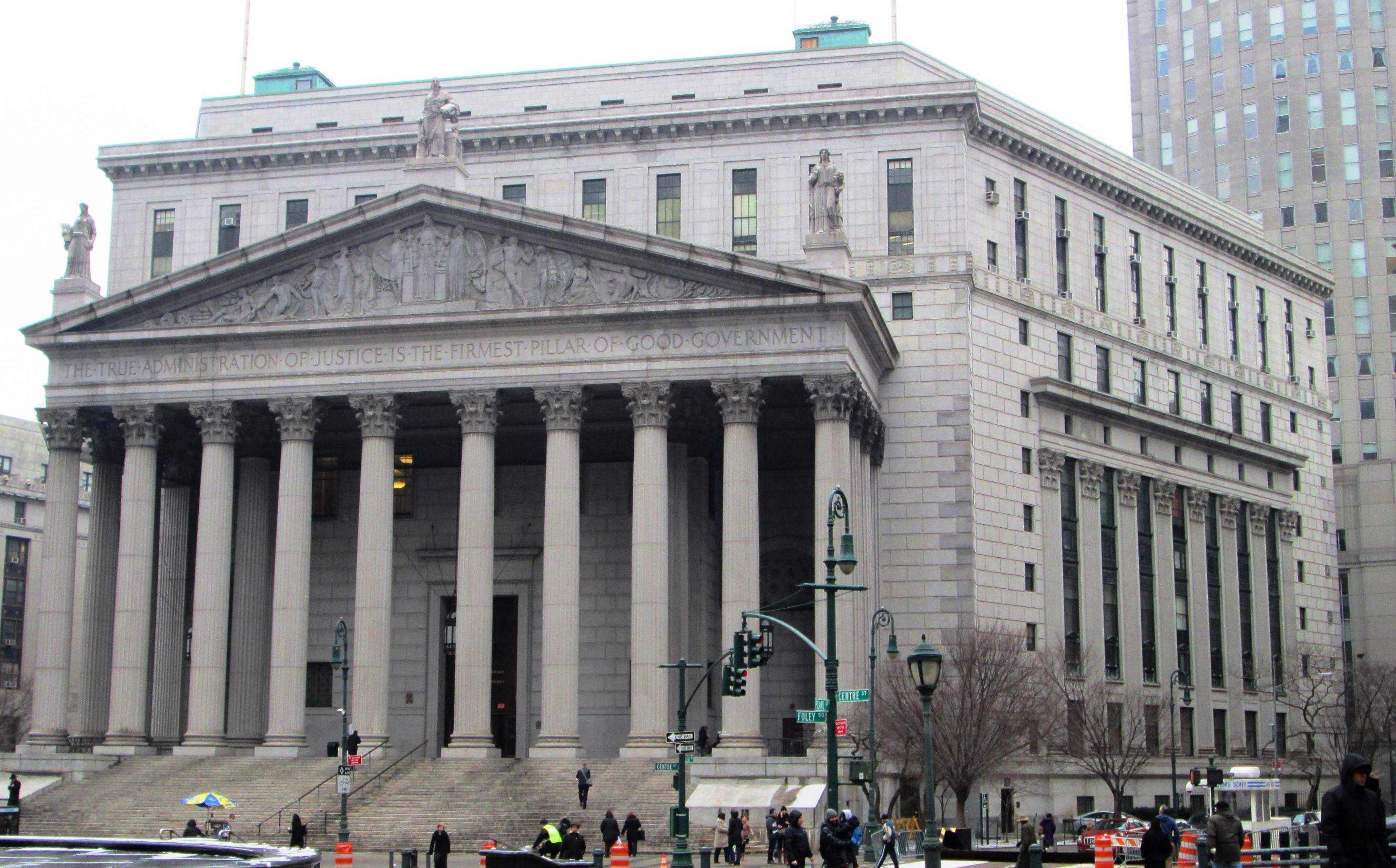 The exterior of the New York County Criminal Court building in Manhattan on an overcast day, photographed in a realistic news style