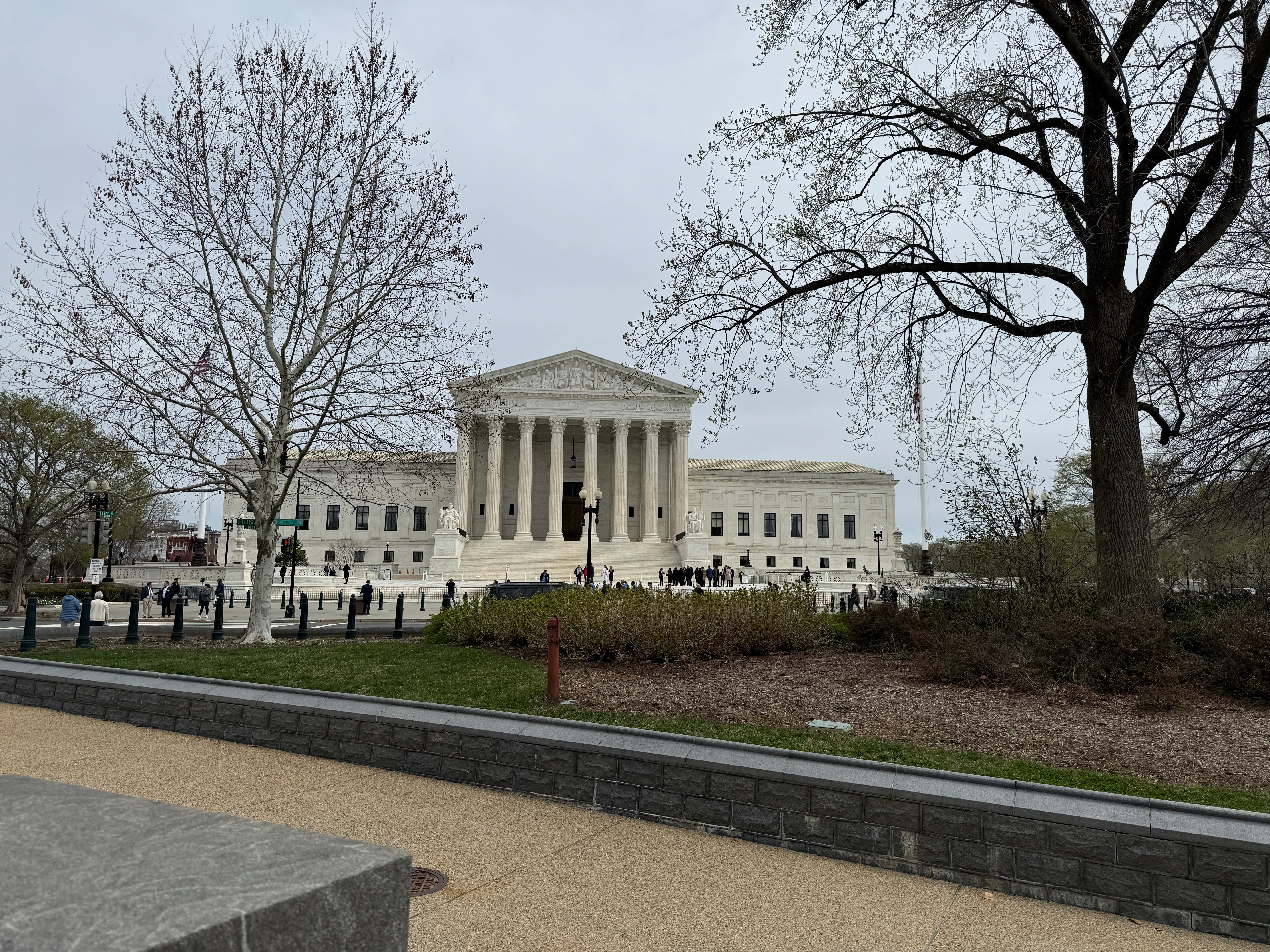 The exterior of the United States Supreme Court building in Washington, DC on a clear day, photographed from ground level with the front steps and columns visible