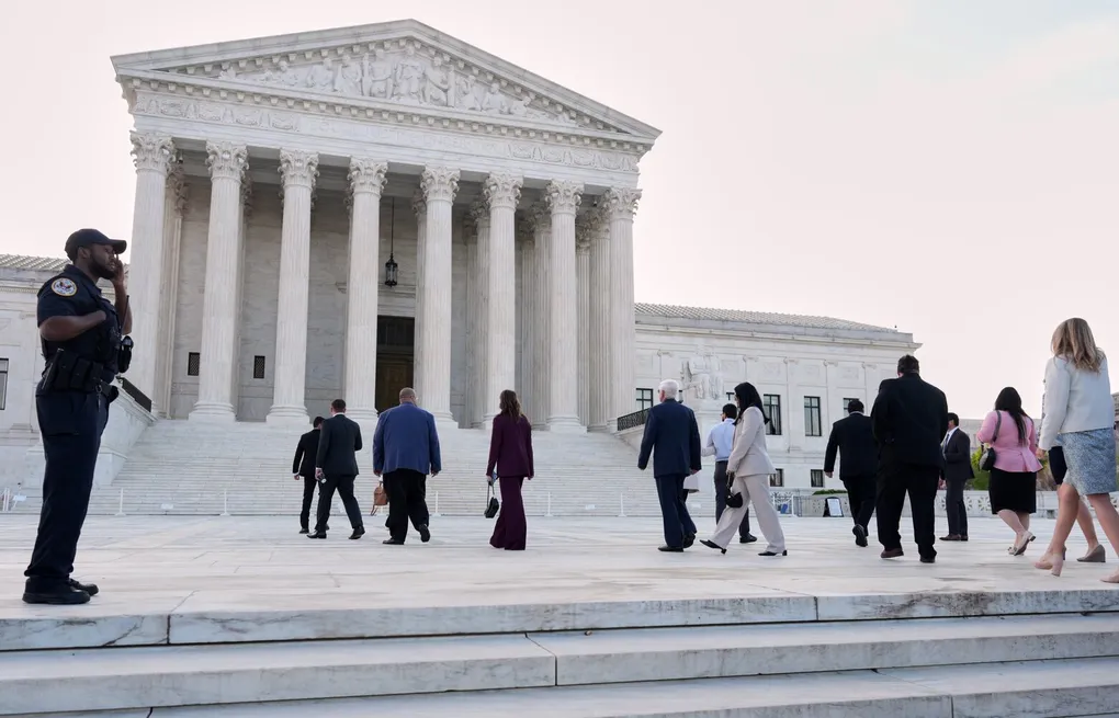 The exterior steps and columns of the United States Supreme Court building in Washington, DC on a clear day, news photography style