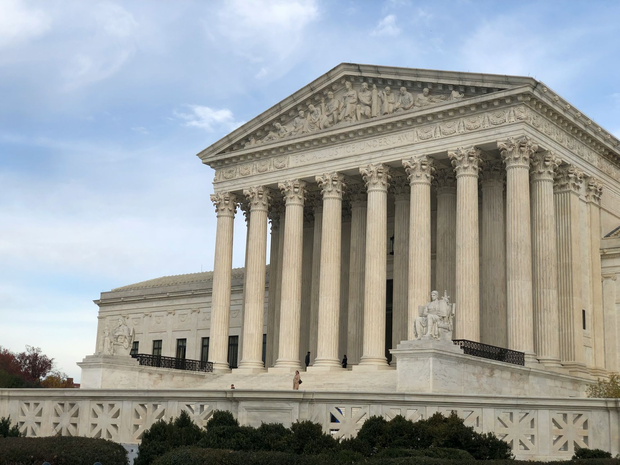The exterior steps and columns of the United States Supreme Court building on a clear day in Washington, D.C., news photo style