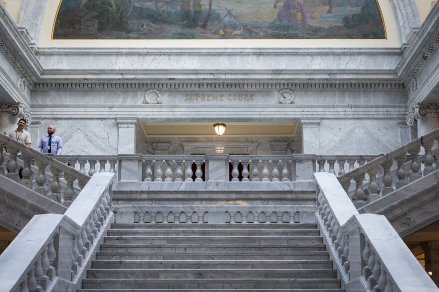 The marble steps and columns of the United States Supreme Court building in Washington, DC on a clear day, photographed straight-on in a realistic news style