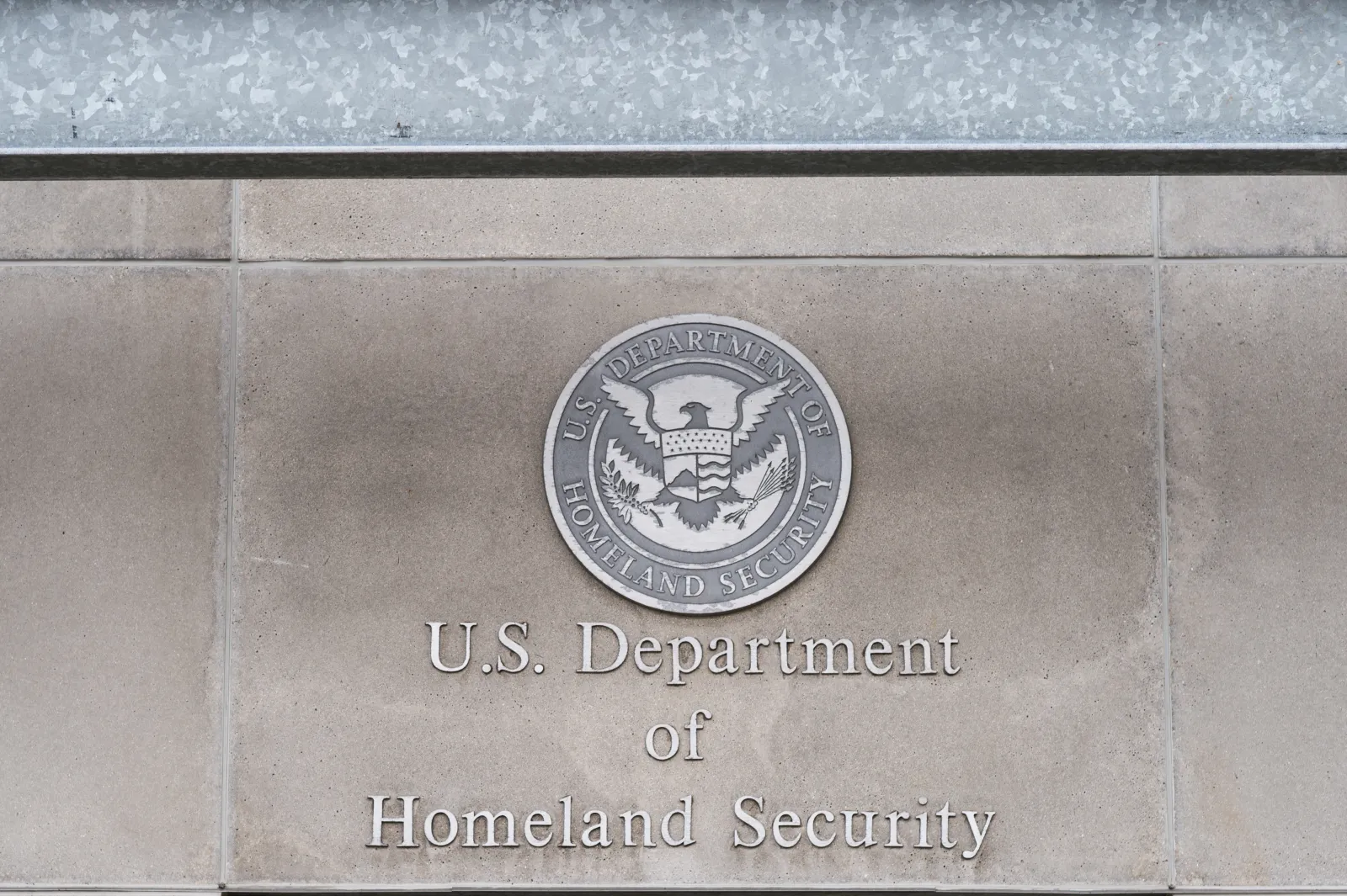 The seal of the U.S. Department of Homeland Security displayed at or near a DHS headquarters entrance in Washington, D.C.