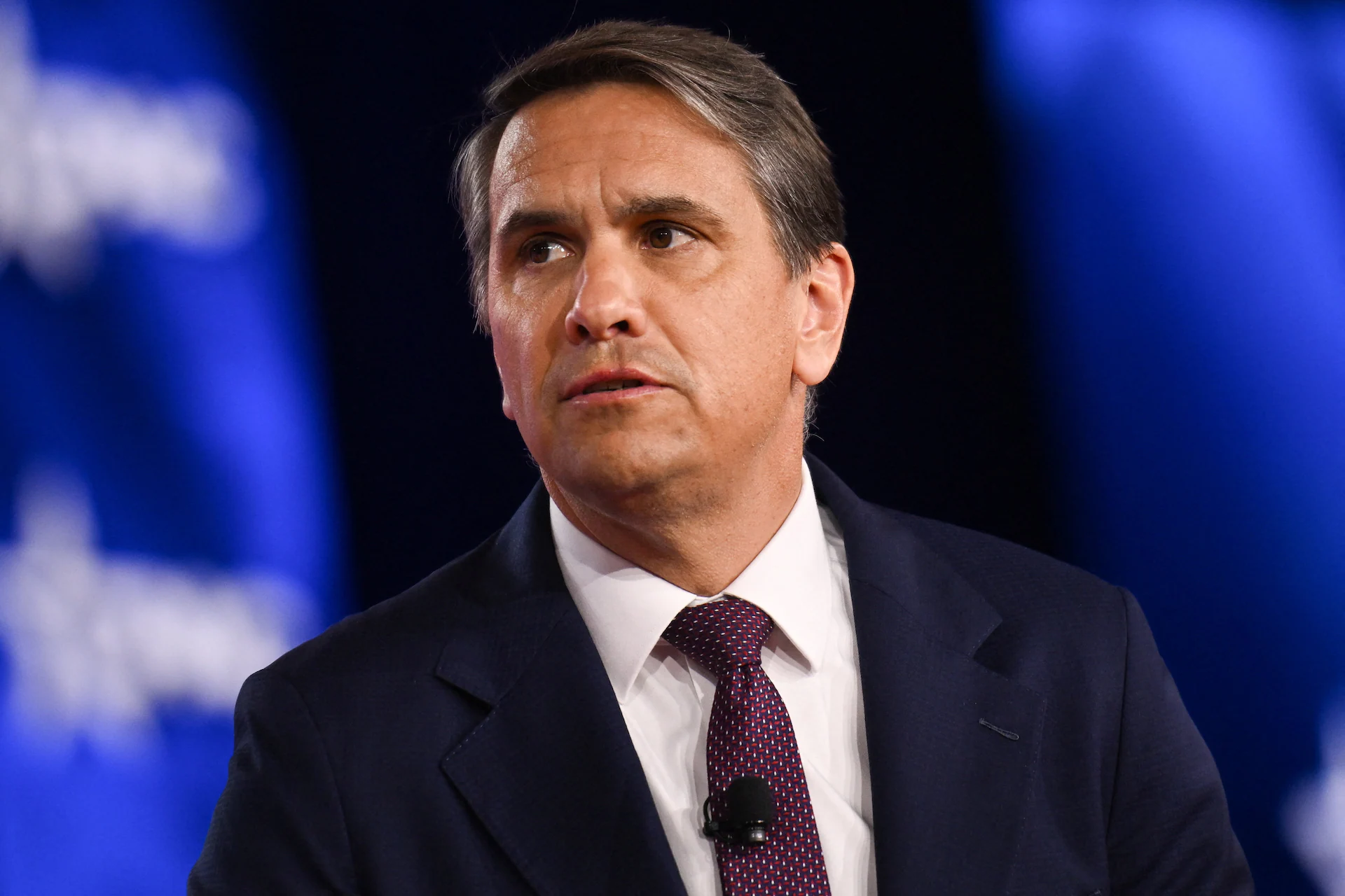 Todd Blanche standing at a Justice Department podium in Washington, D.C., during an indoor press moment, news photography style