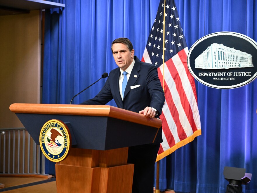 Todd Blanche walking toward the U.S. Department of Justice headquarters in Washington, D.C., wearing a suit, news photography style