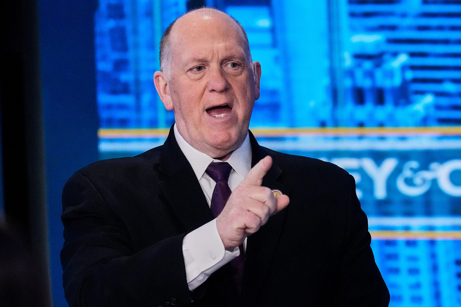 Tom Homan speaking during a televised Sunday news interview, seated indoors with studio lighting, news photography style